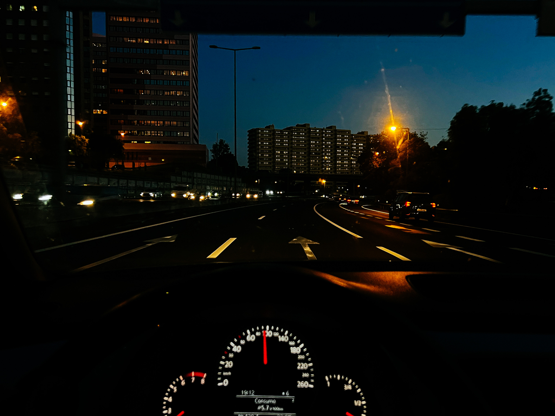 View from the drivers seat, sunset, buildings in front of us 