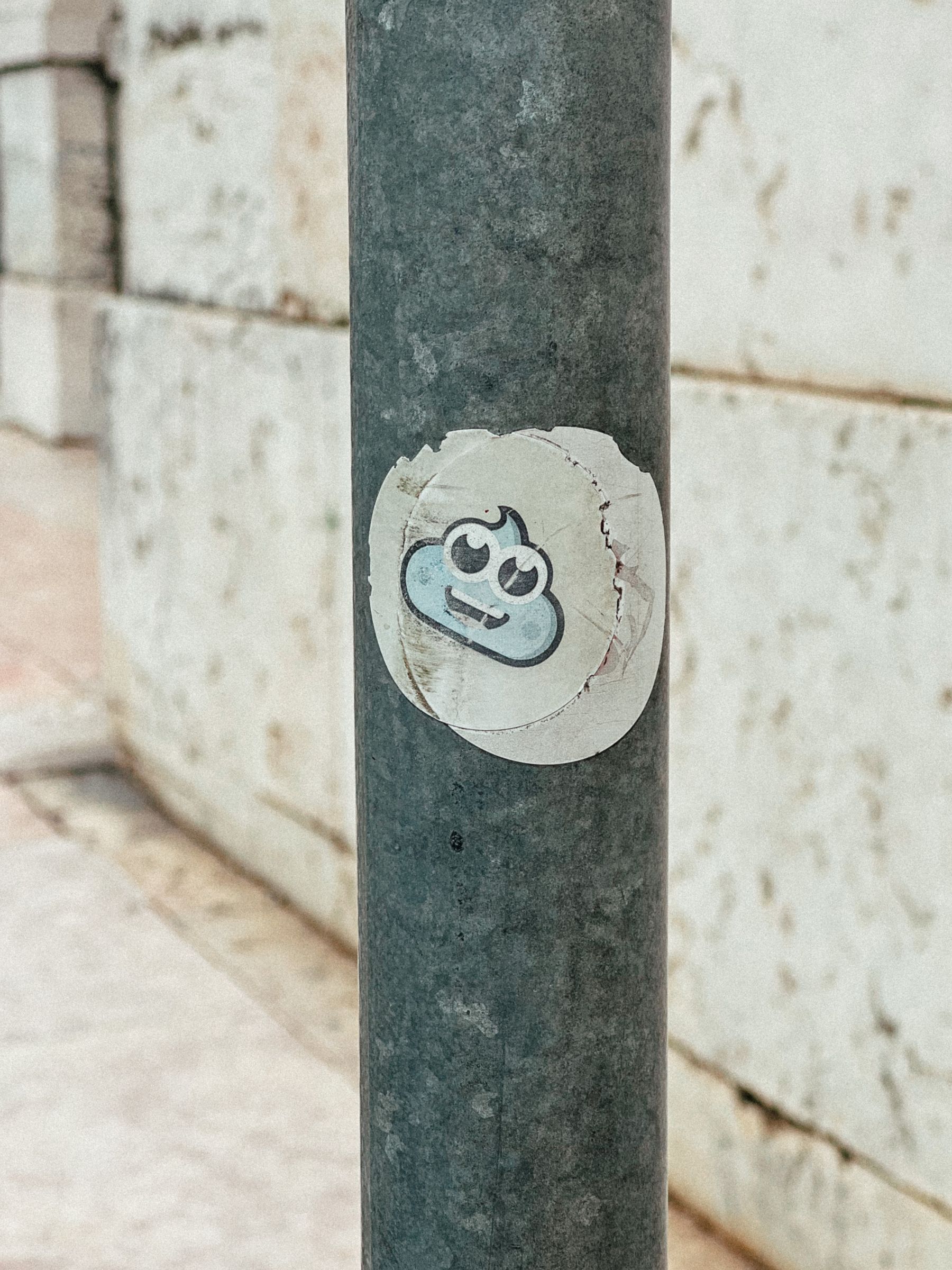A faded sticker, originally a blue poo emoji.