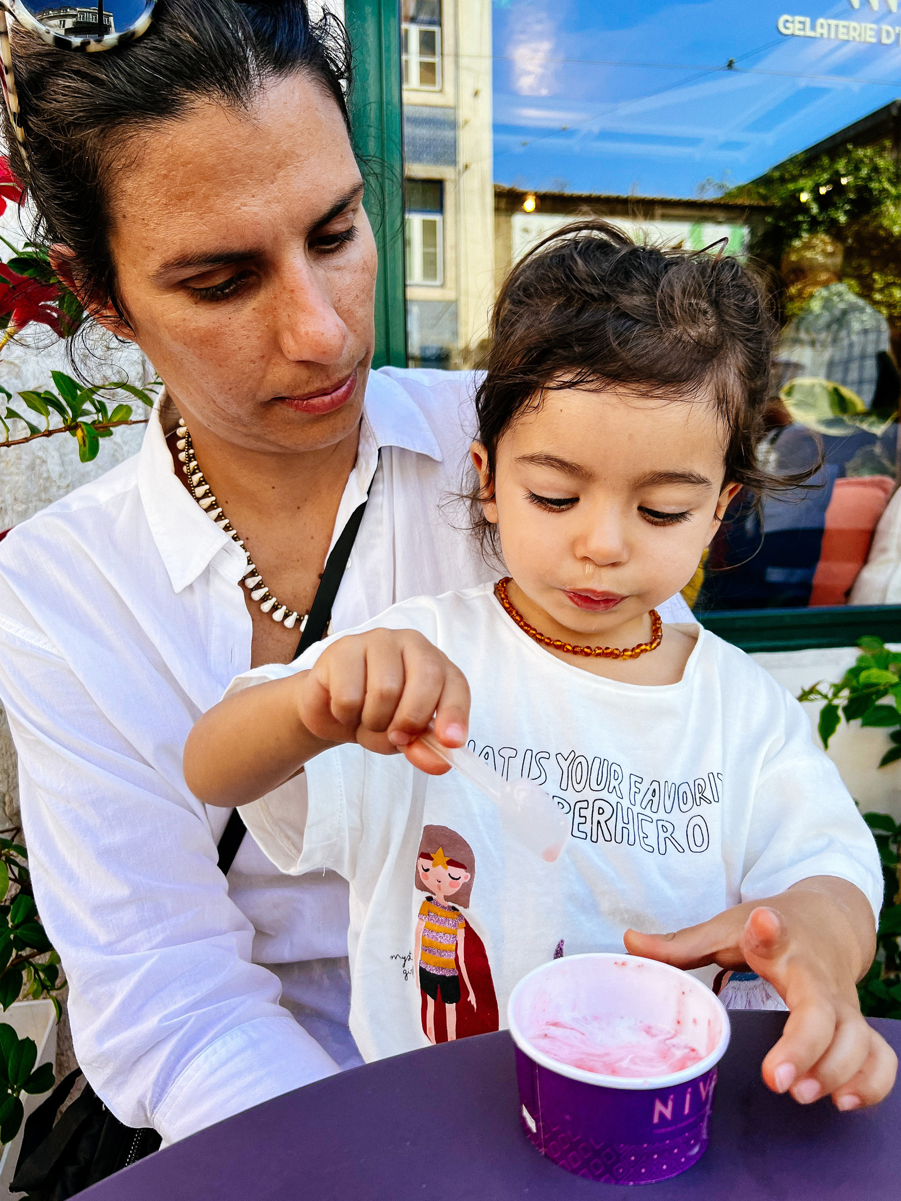 Mom and daughter sharing an ice-cream. 