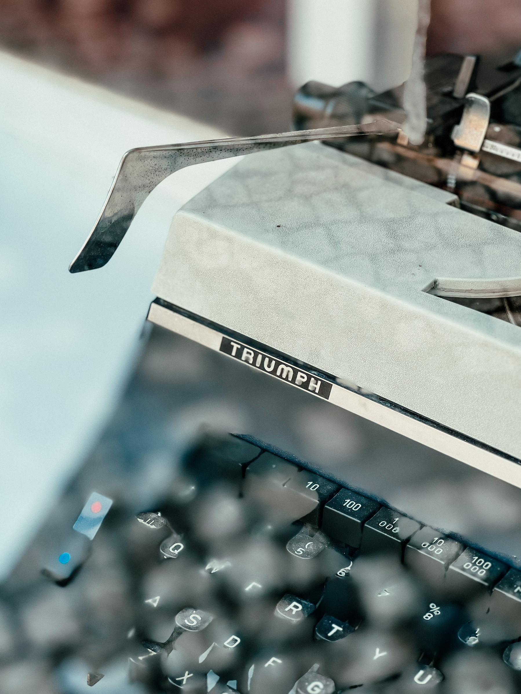 Detail of a typewriter, the word “Triumph” is visible. 