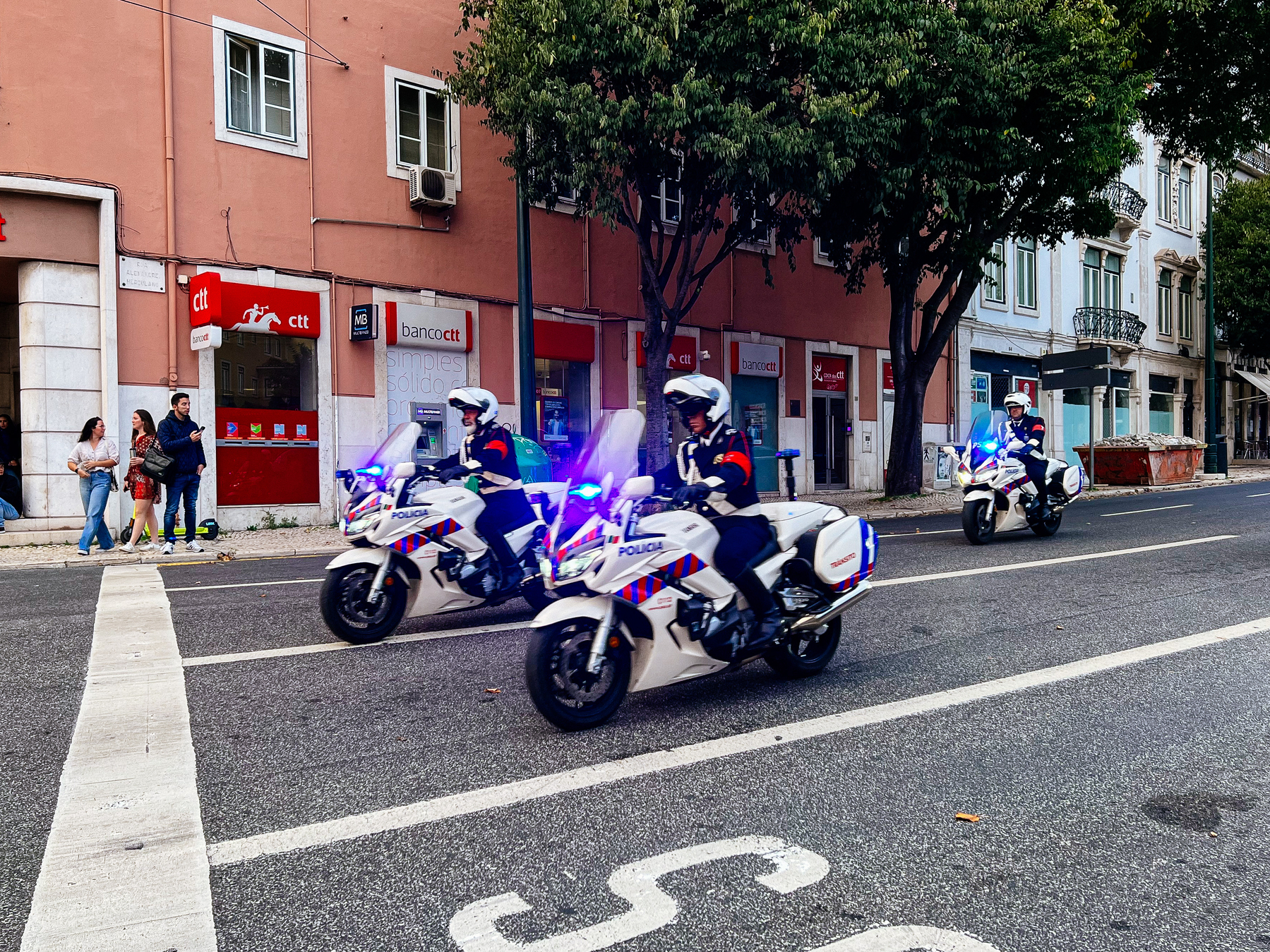 three policemen on motorcycles riding through town