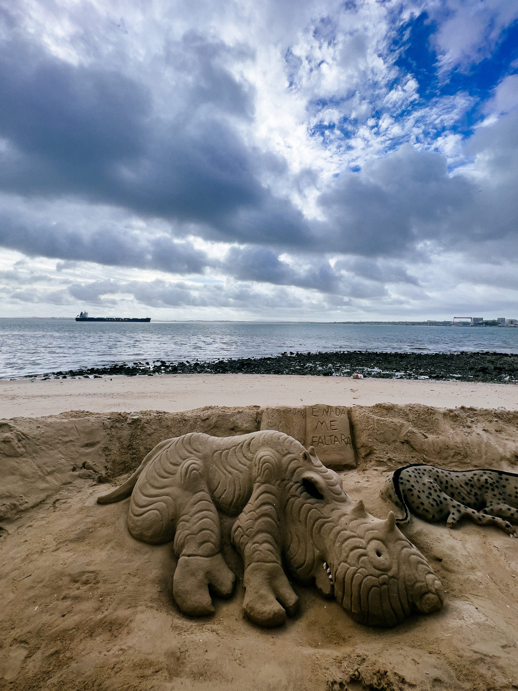 An animal made of sand on the river bank 