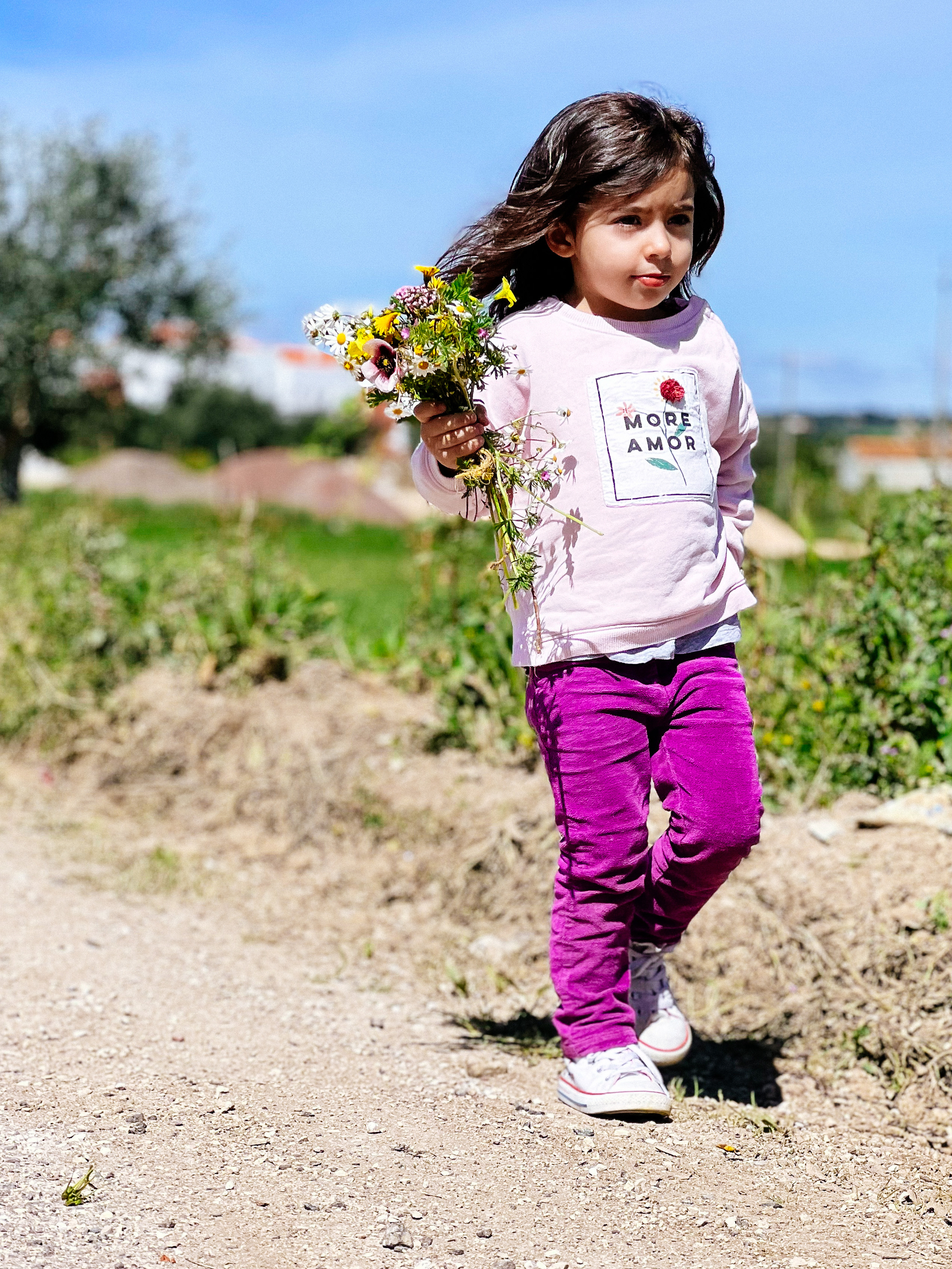A little girl with a bunch of flowers. 