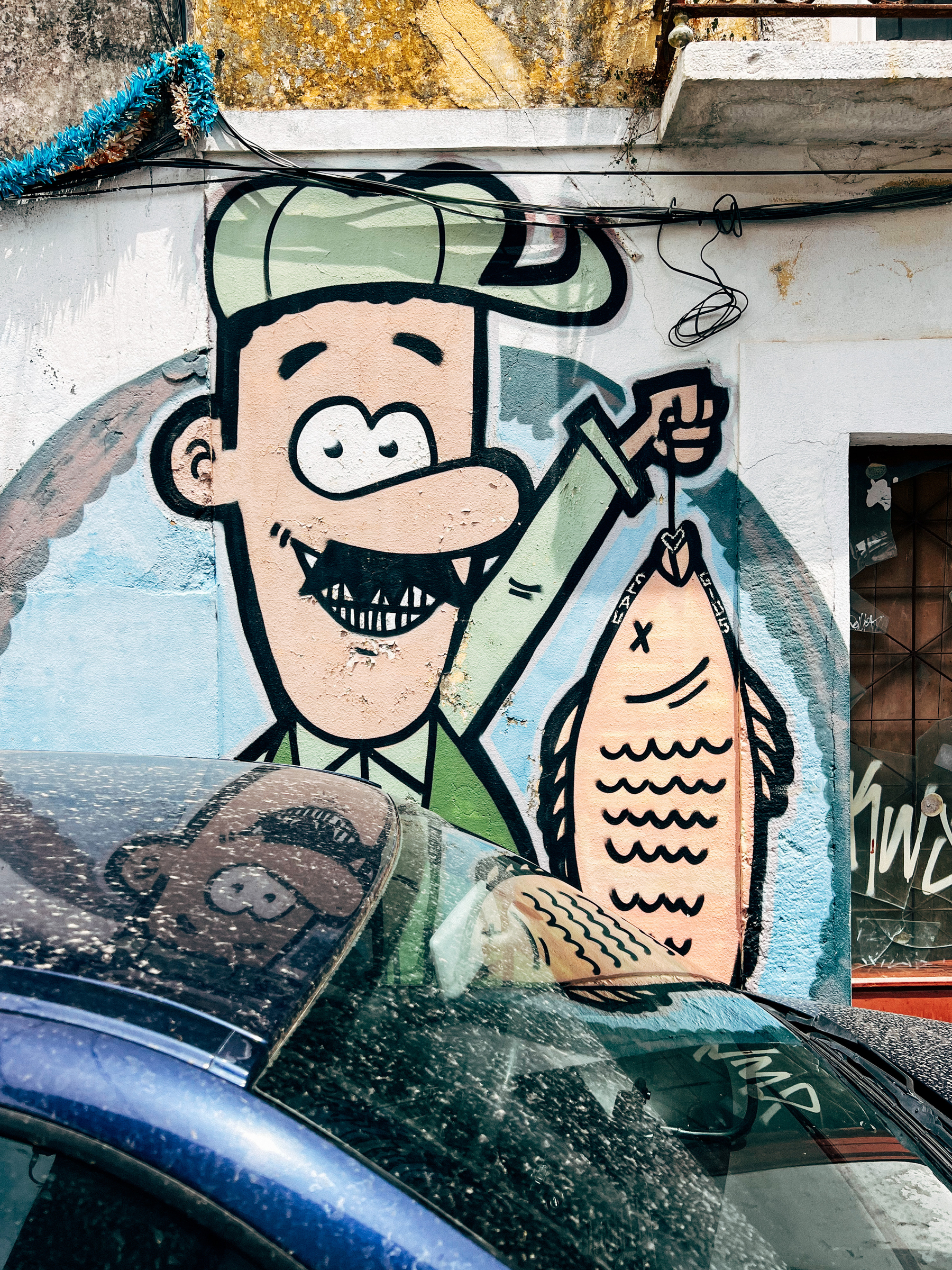 A cartoony graffiti. A man holding a fish. 