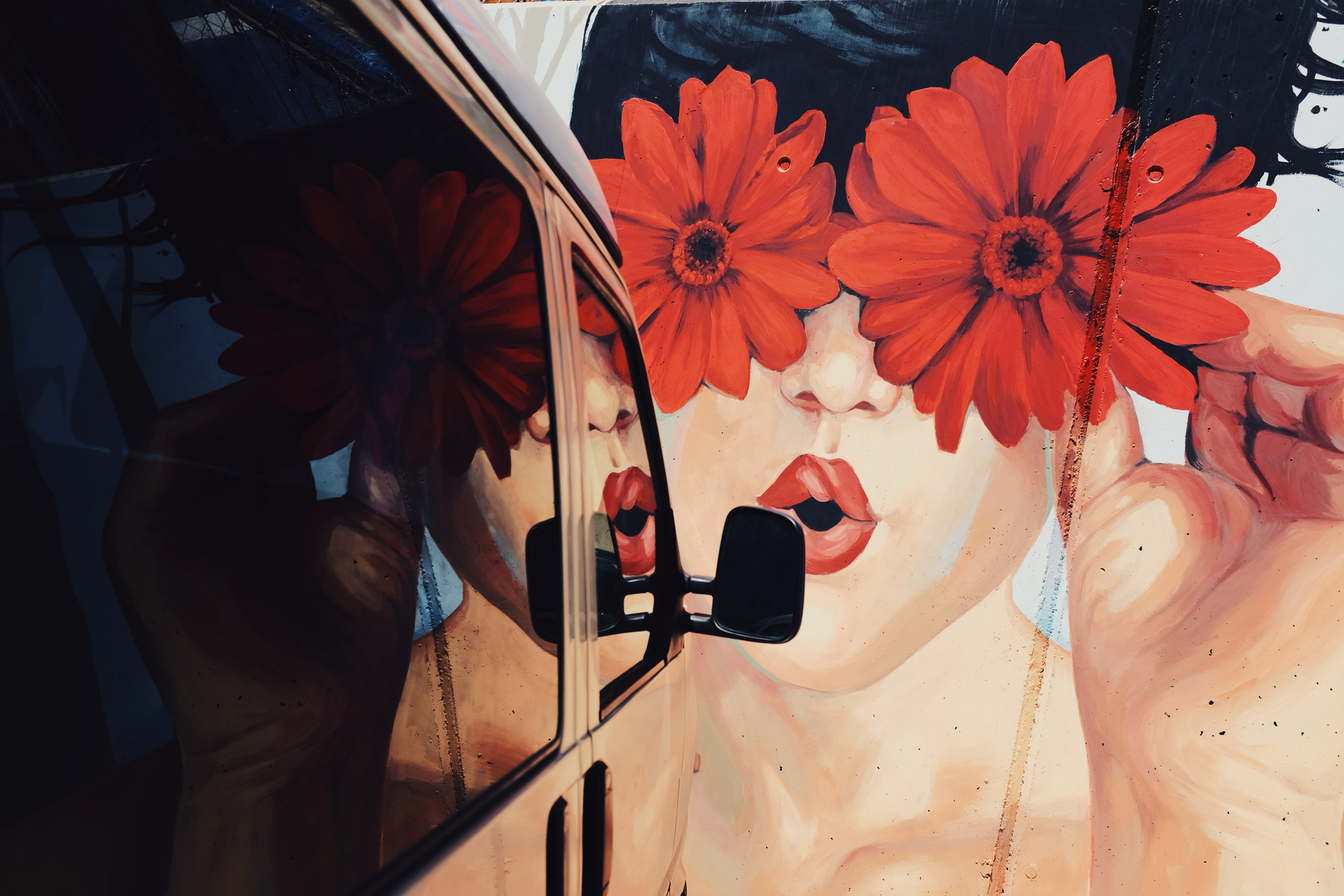 Street art, a girl blows us a kiss, flowers for eyes.
