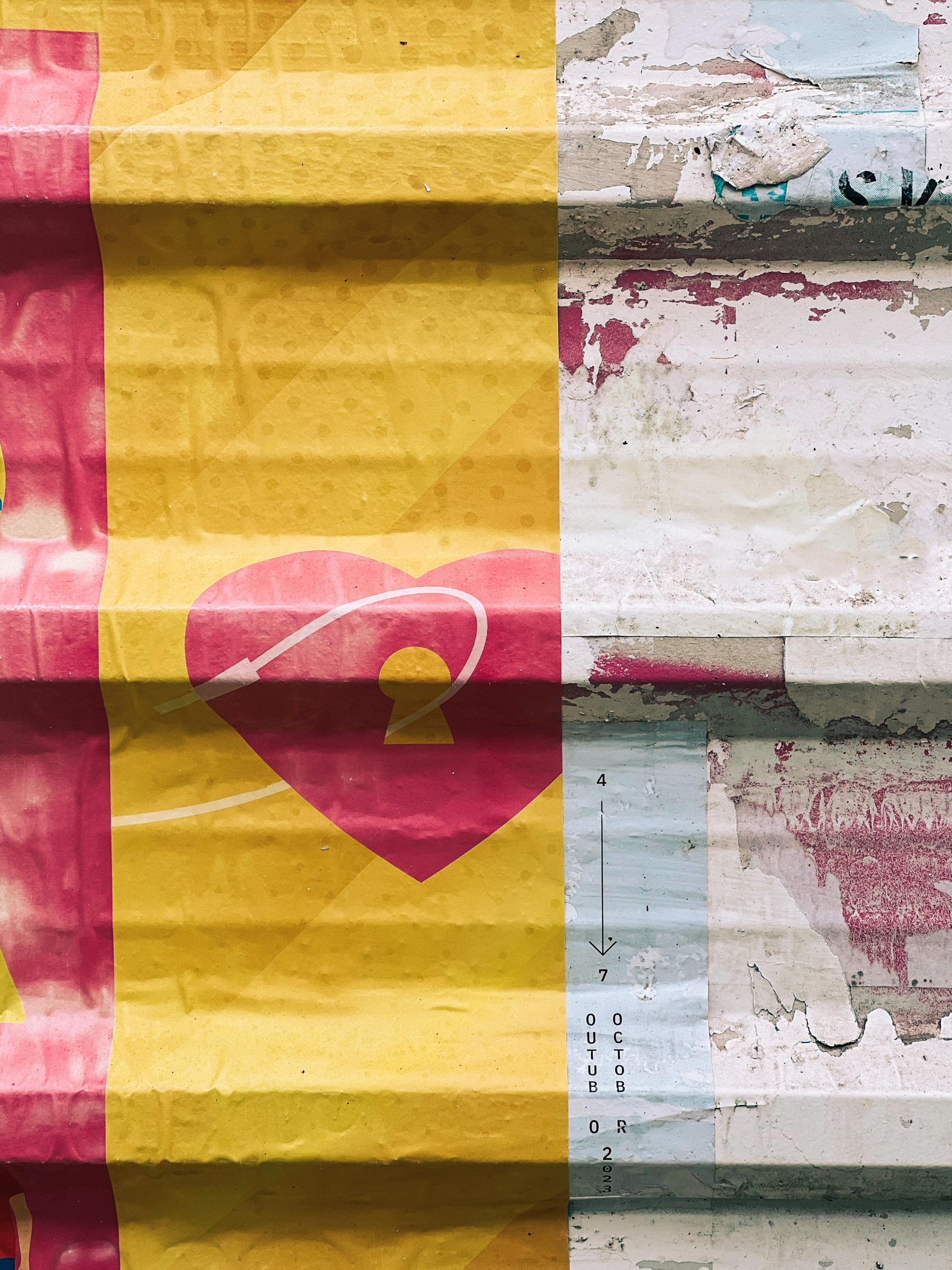 This image shows a juxtaposition of two different textures. On the left side, there is a vibrant, yellow and pink patterned poster with a graphic design that includes a heart shape. On the right side, a weathered wall with peeling layers.