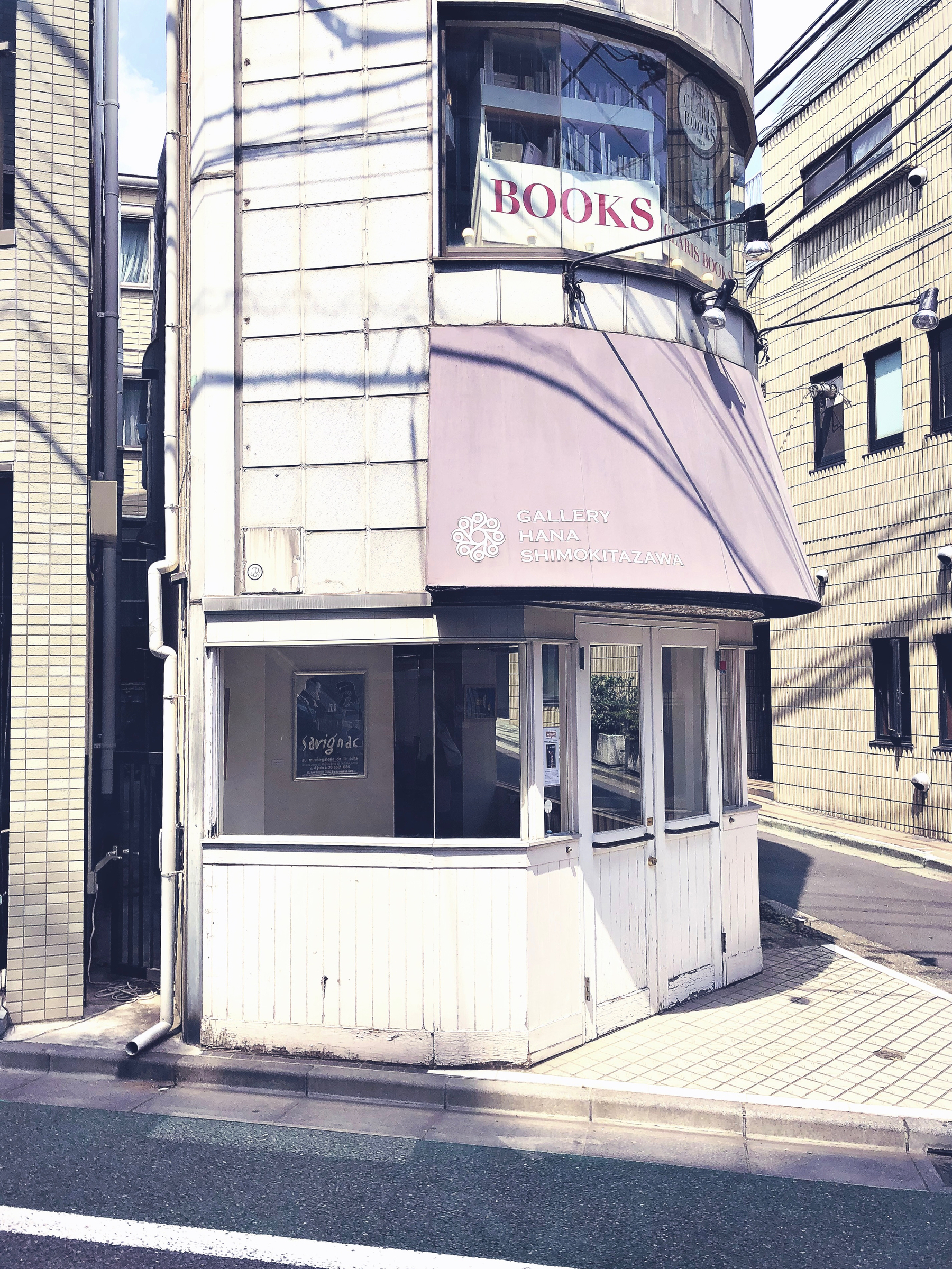 An art gallery’s window, with a “books” sign on the first floor. 