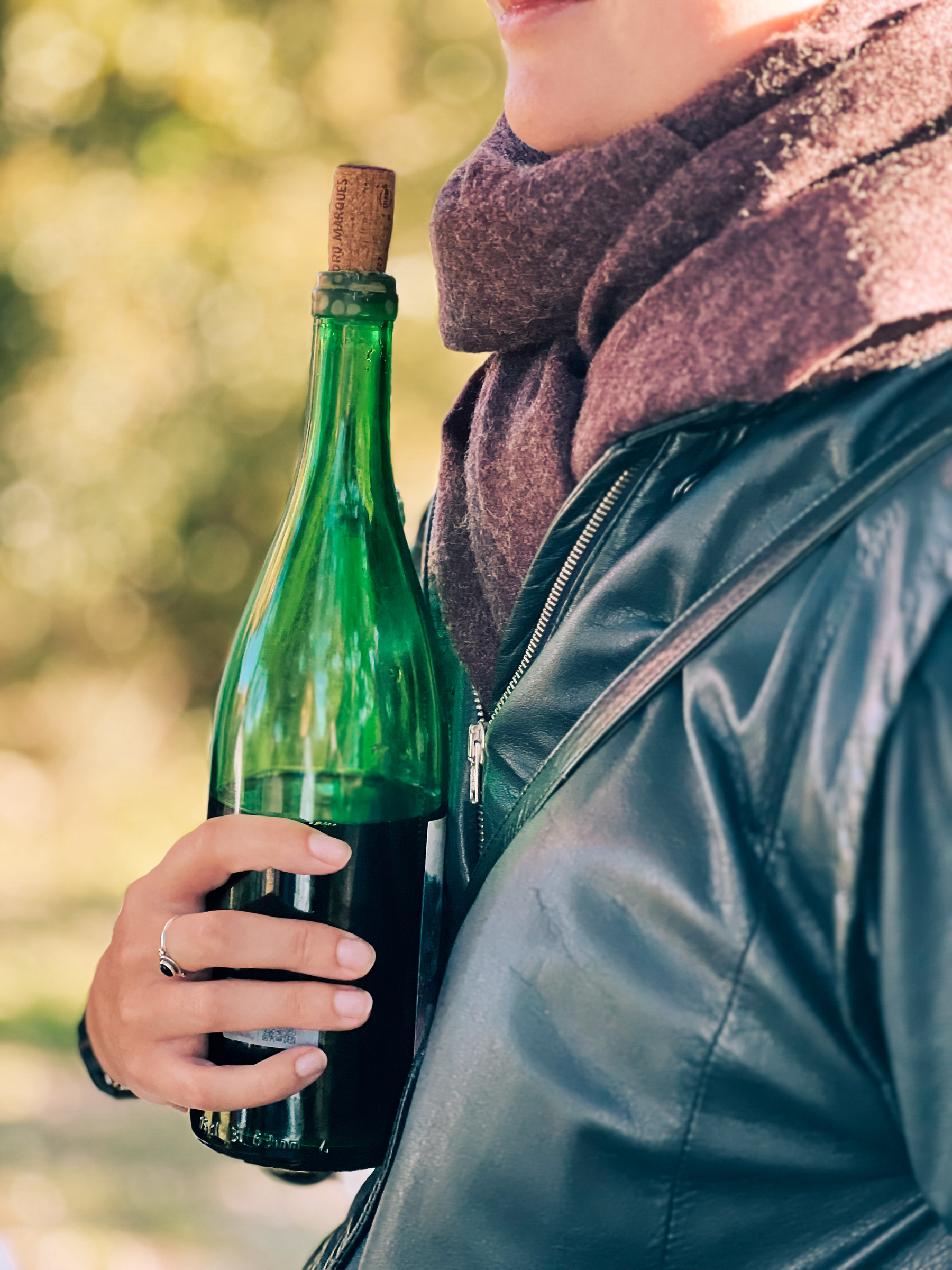A girl holding a bottle of wine.