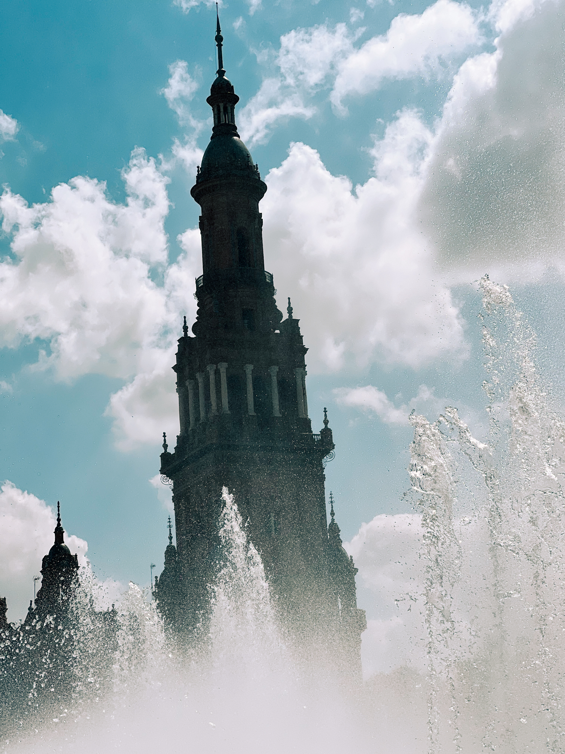 A fountain, and a tower in the background. 