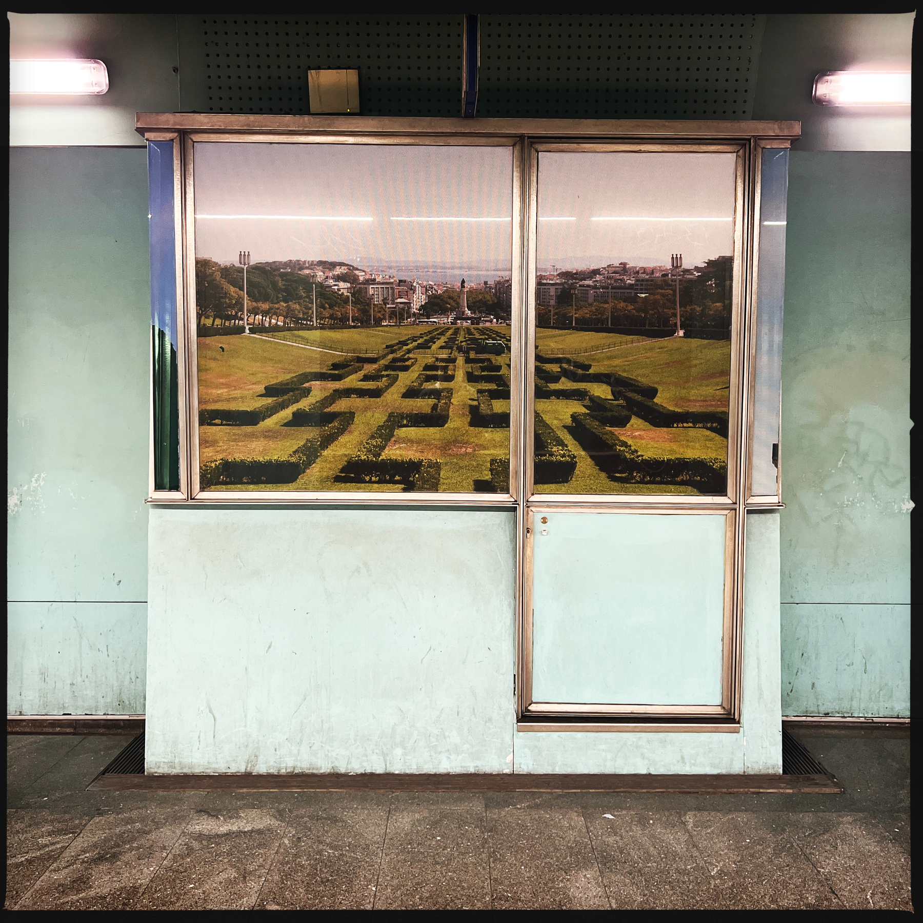 a booth inside a metro station, with a photo of a park.