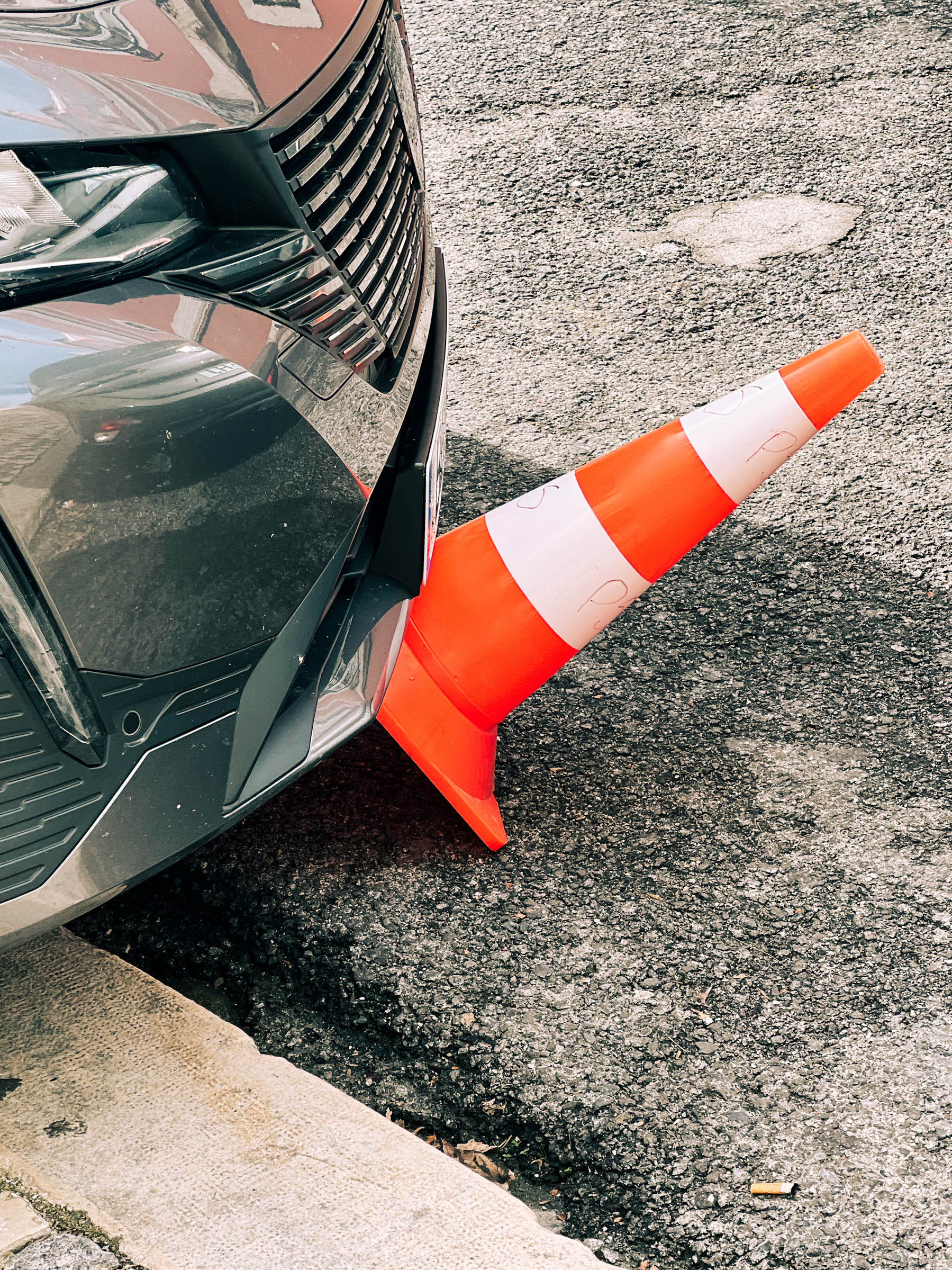 A car ran over a traffic cone. 