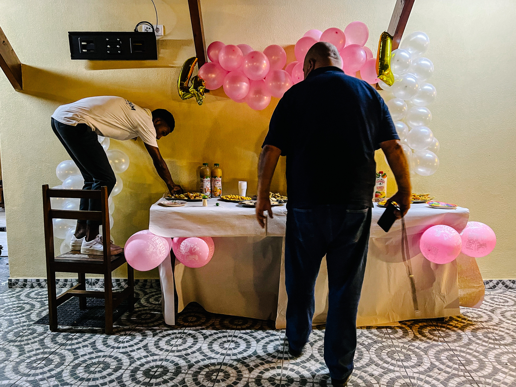 Two men set up a table for a kid’s birthday party. 