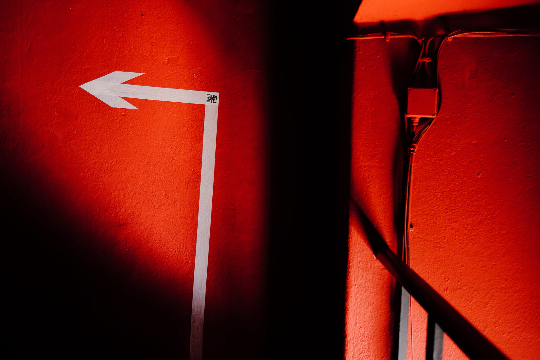 A red wall with a white arrow.