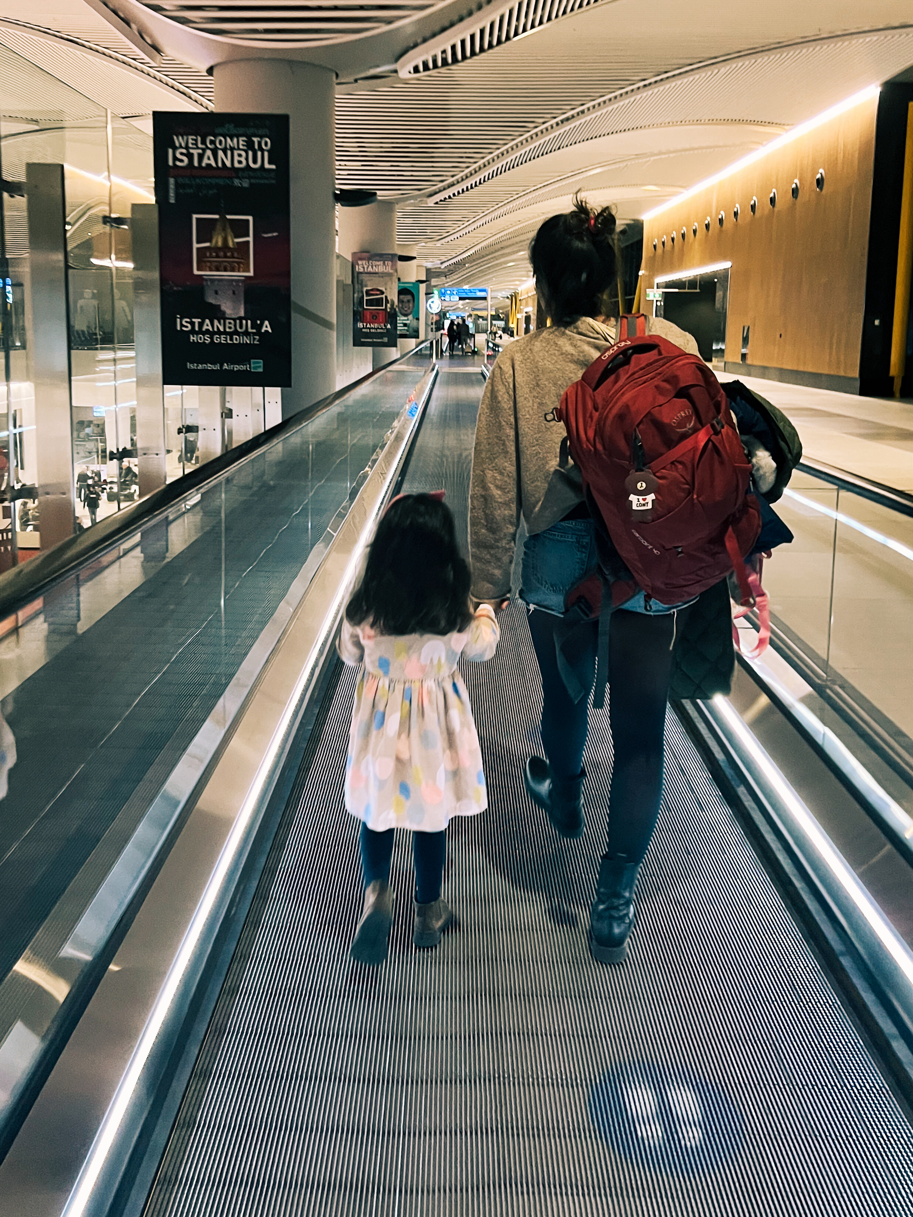 Mom and toddler, walking in the airport. 
