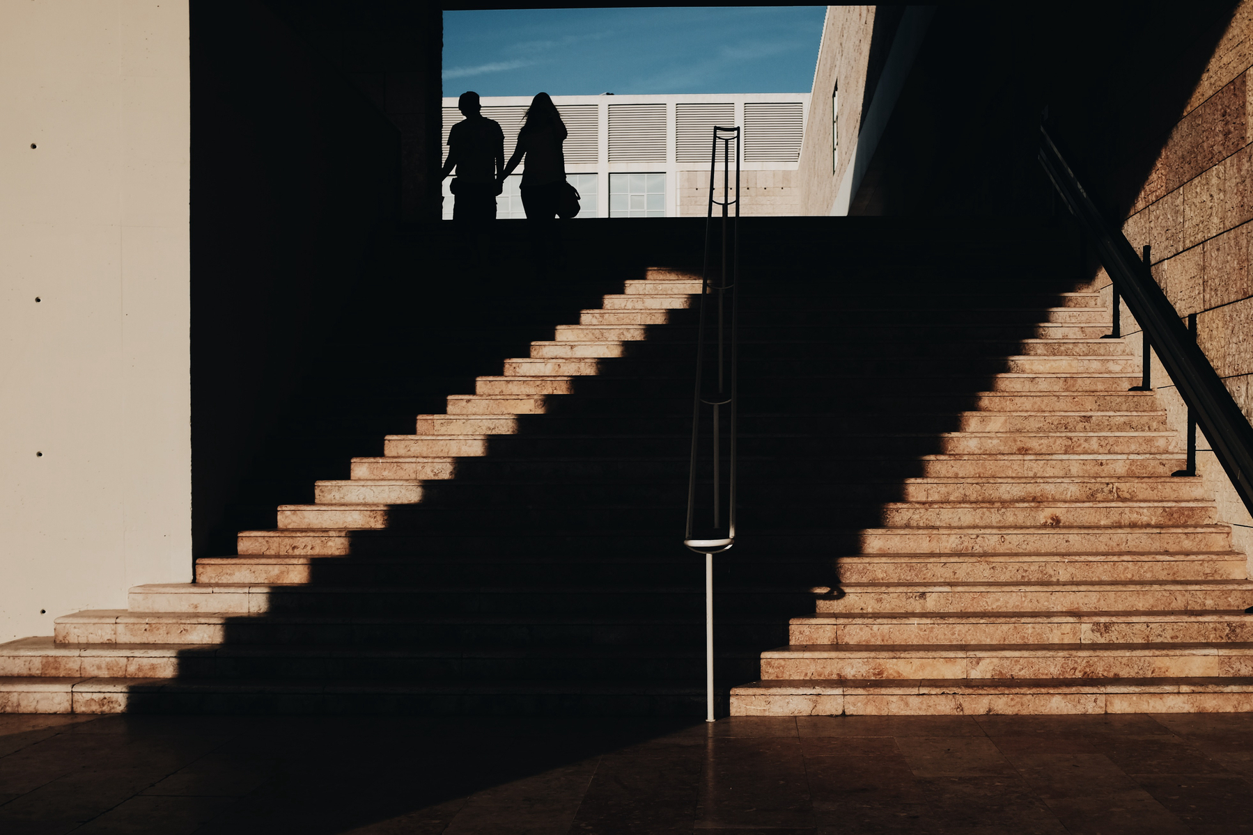 A couple at the top of a stairway.