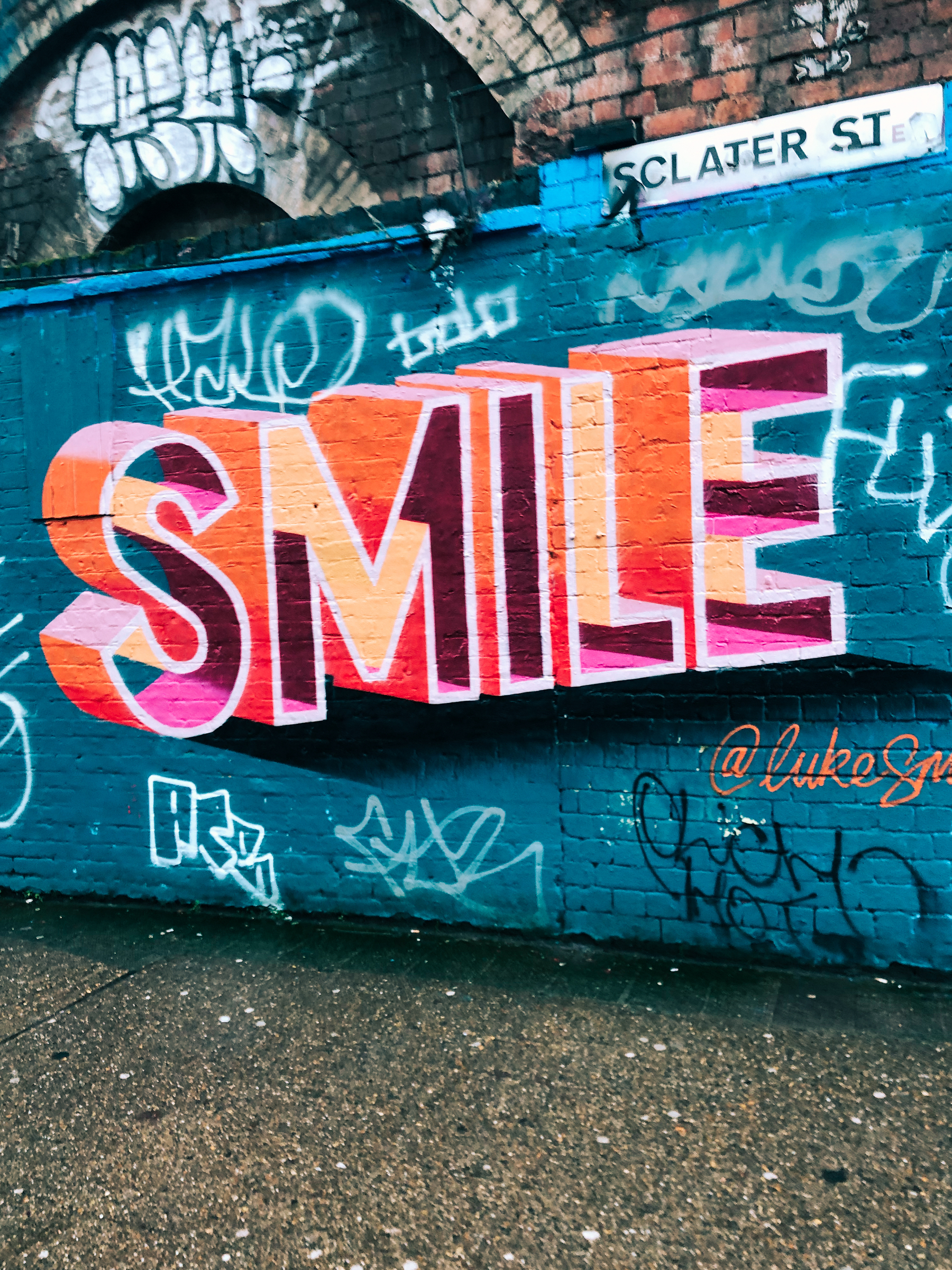 Graffitied wall. The word &ldquo;Smile&rdquo;.