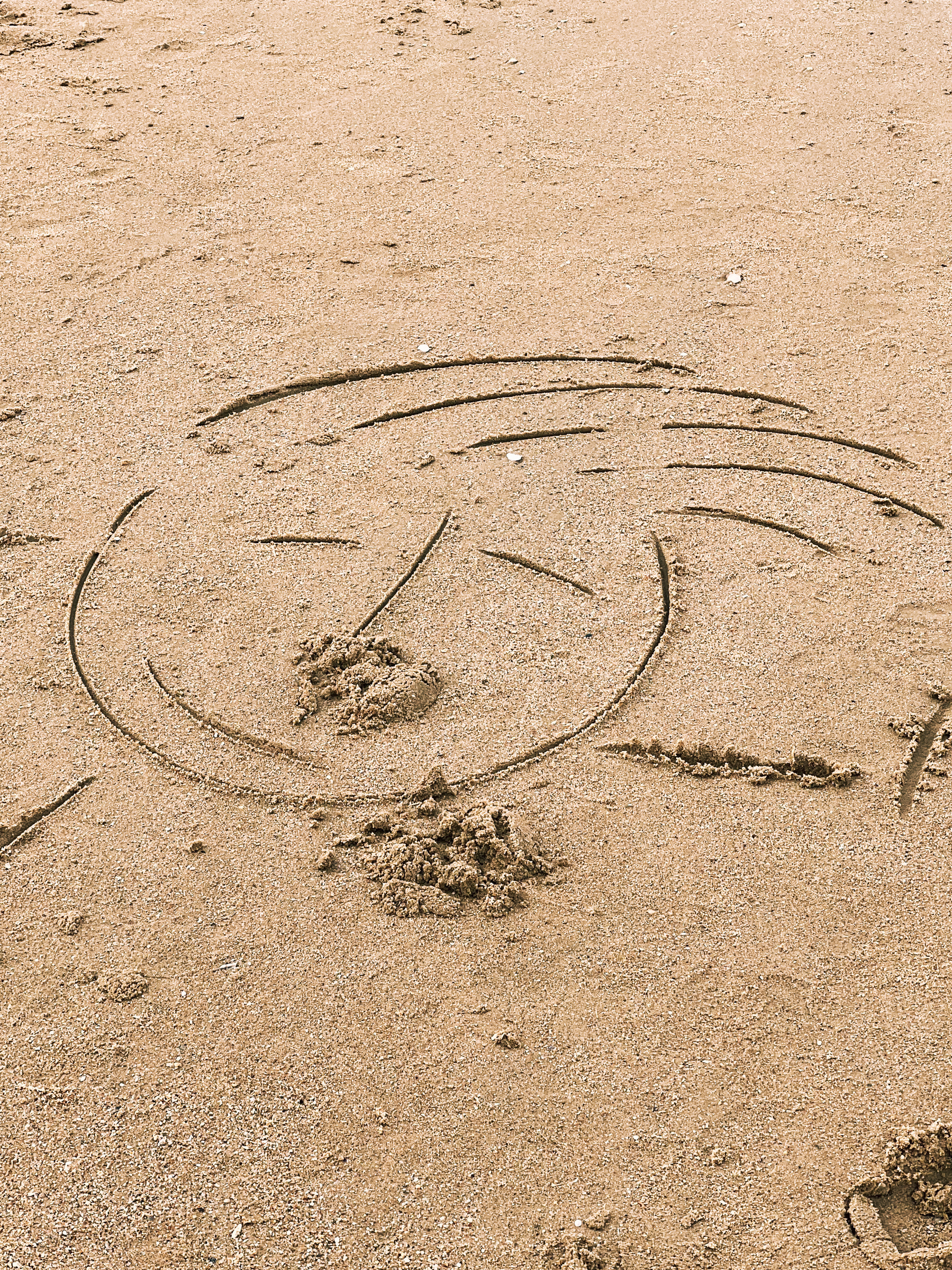 A face drawn in the sand. 