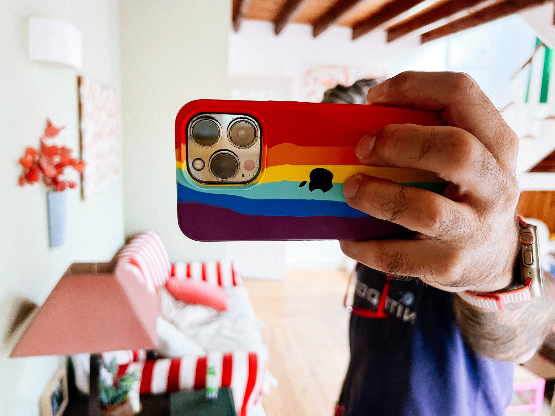 An iPhone with a rainbow colored case. 