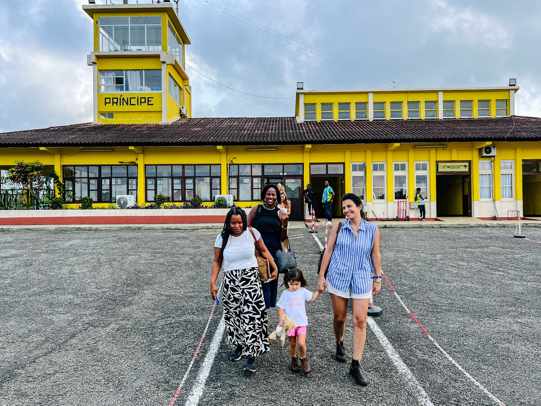 A yellow building, with the word “Príncipe” written on it, and four girls walking towards us. One is a toddler, the others grownup