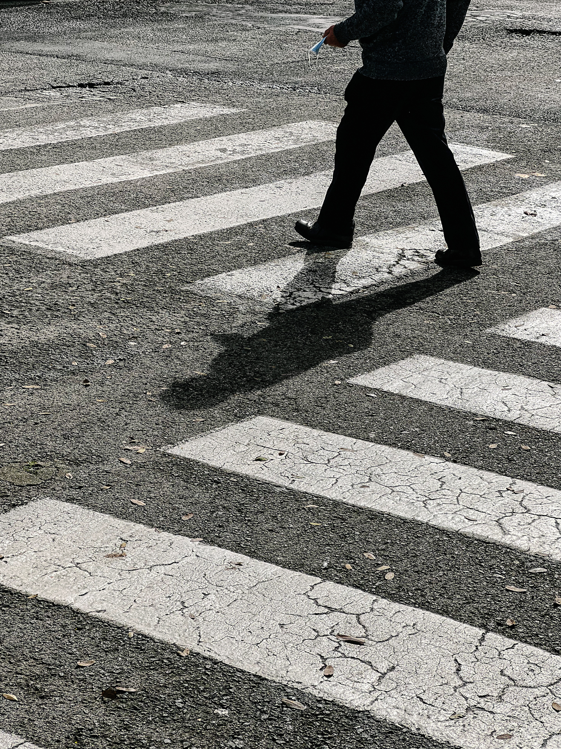A man is seen walking on a crosswalk.