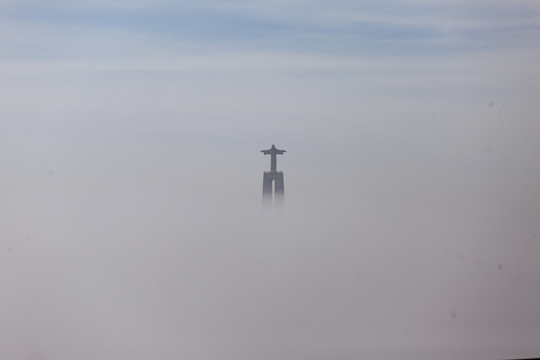 A statue is seen in the fog. 