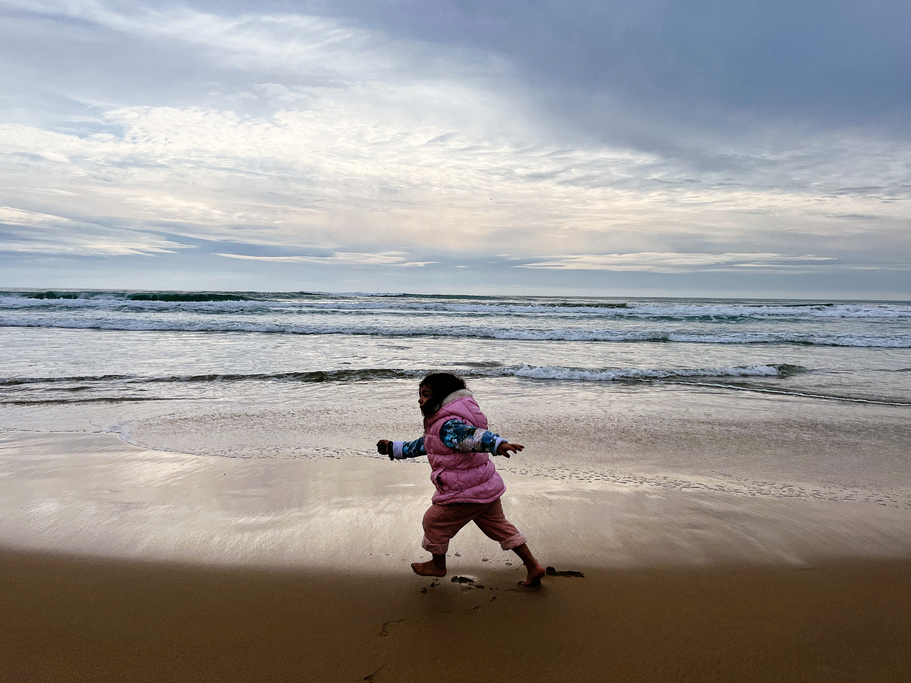 A kid plays in the beach. 