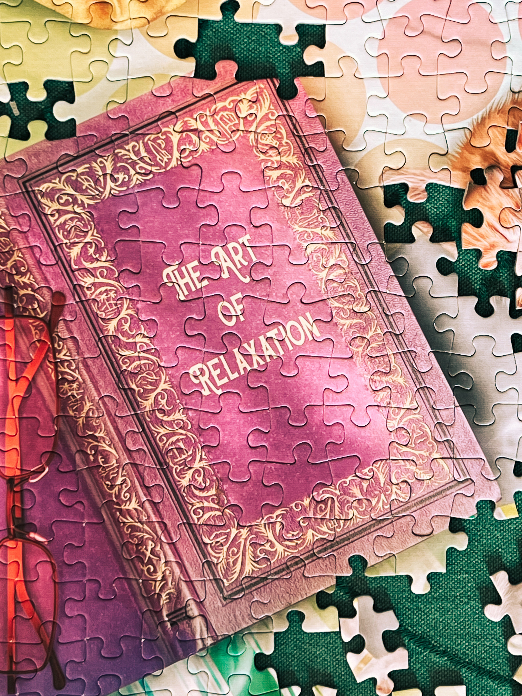 A partially assembled jigsaw puzzle featuring an image of a book with the title &ldquo;The Art of Relaxation&rdquo; on its cover. Some puzzle pieces are unconnected around the edges.