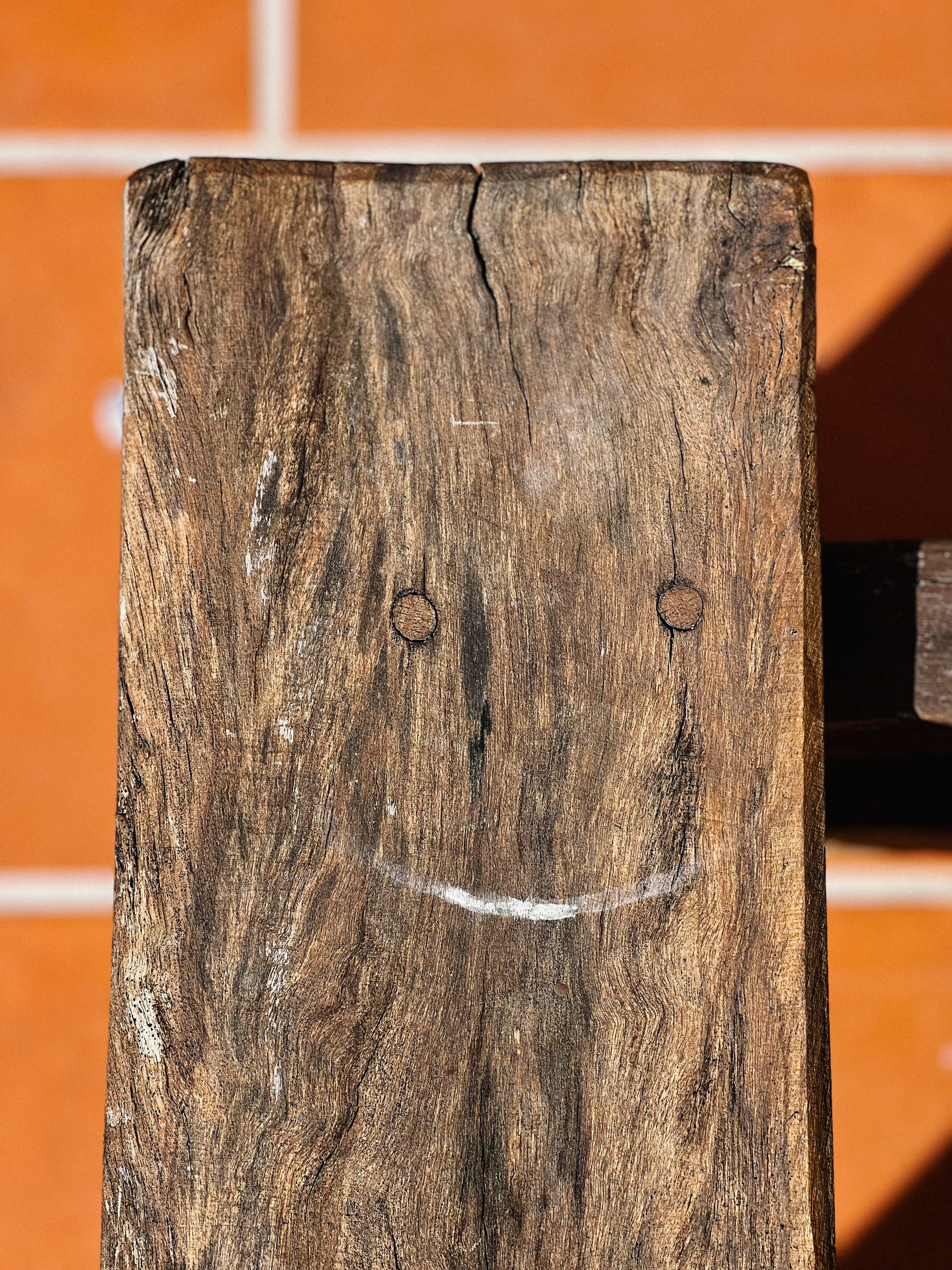 A smiley face on a piece of wood. 