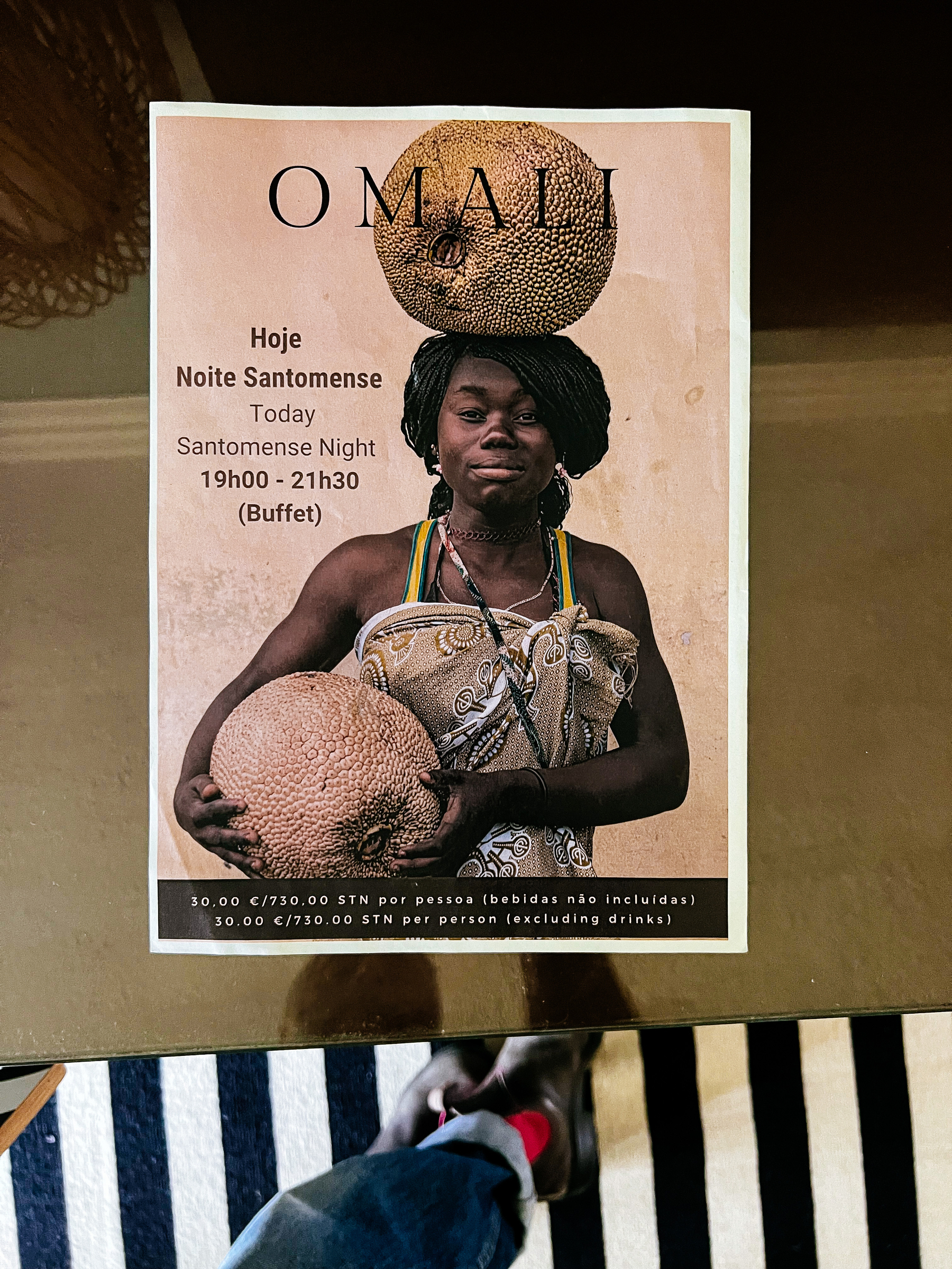 Looking down on a flyer. There’s a photo of a woman carrying fruit on her head, and hands. 