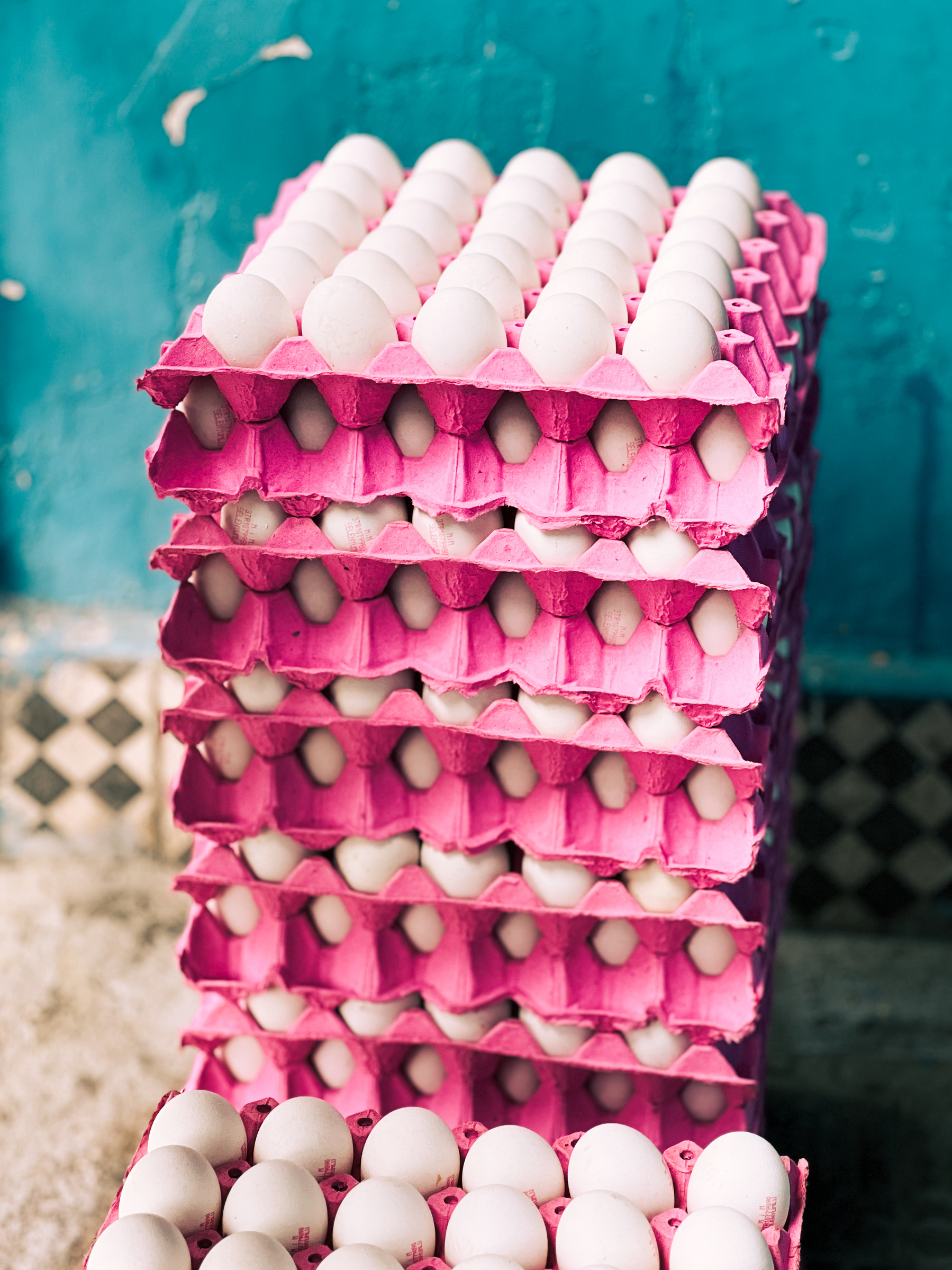 A pile of pink boxes with eggs. 