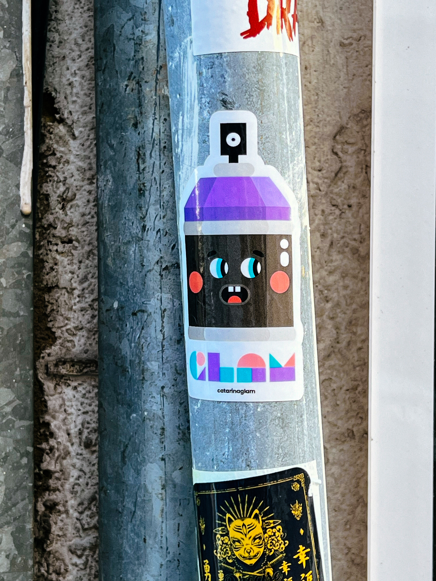A spray can with a face, and the word “Glam”. On a sticker. 
