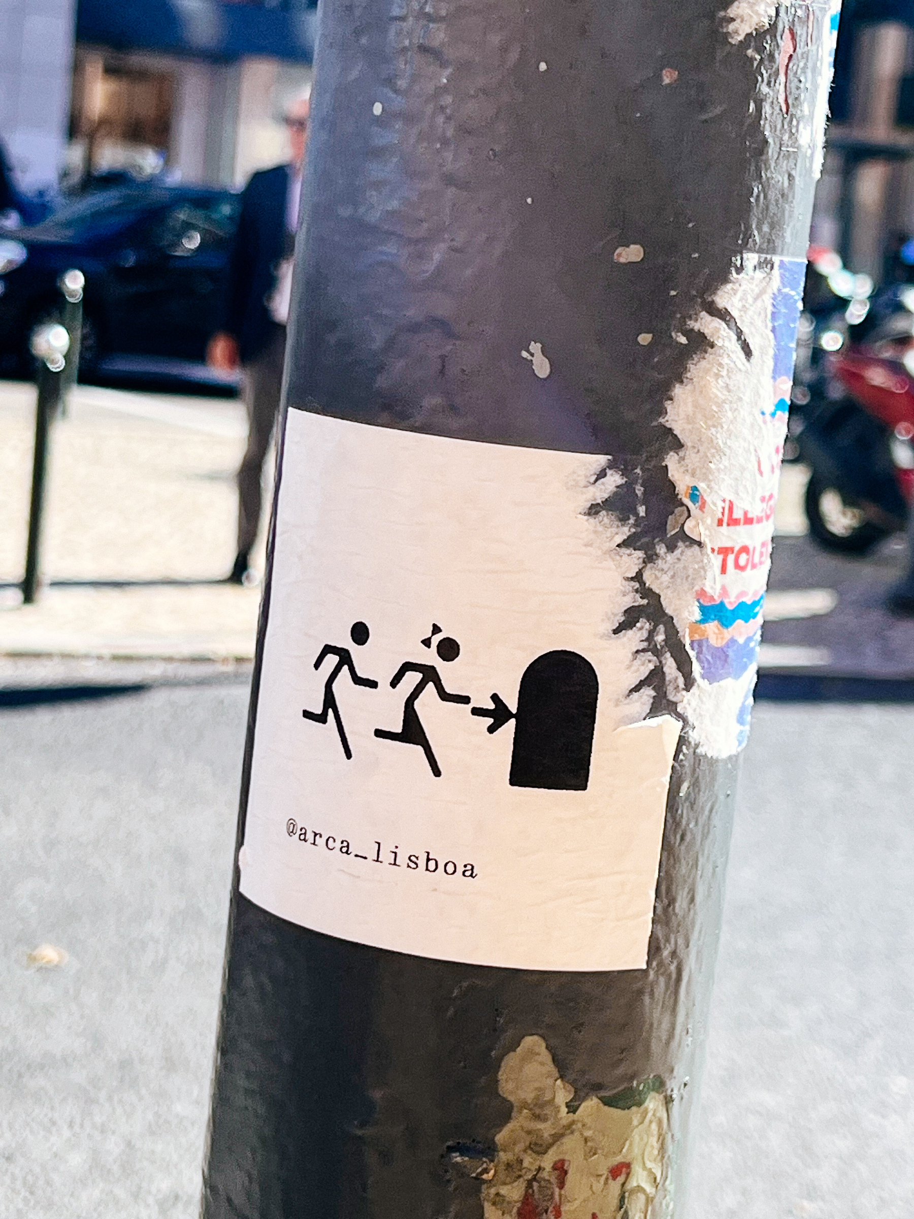 A girl and a boy stick figures run in the direction of a door. A sticker. 