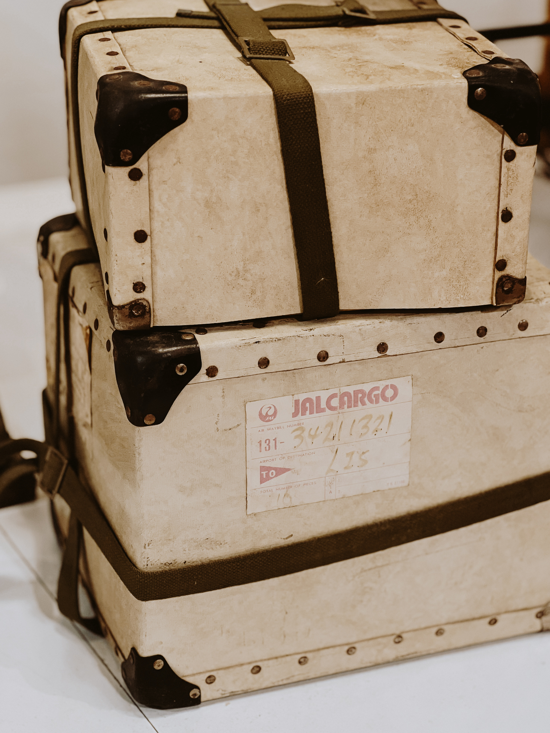 Stacked vintage suitcases with travel stickers and straps.