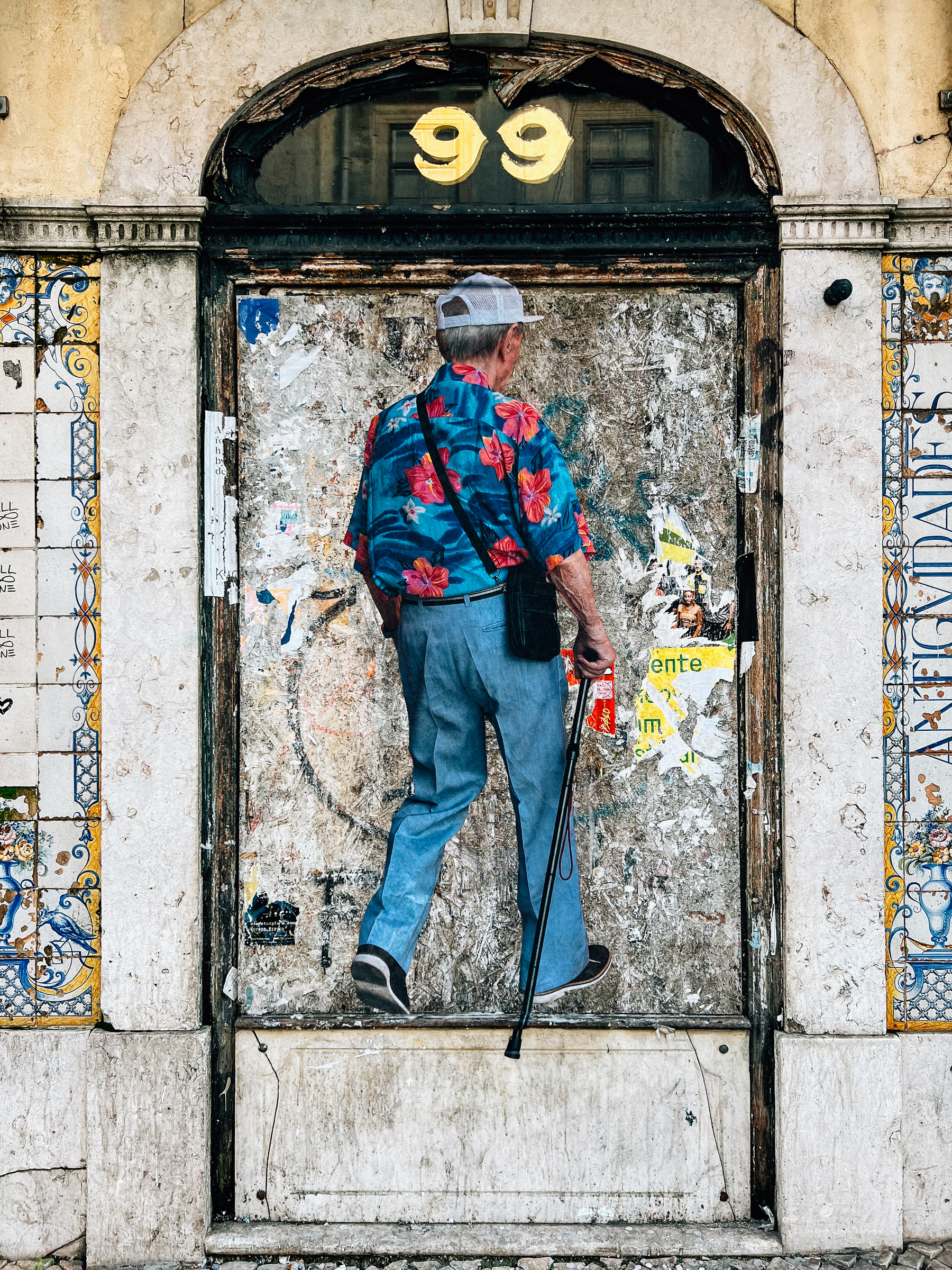 A giant sticker of person with a colorful floral shirt and a walking stick, surrounded by decorative tiles.