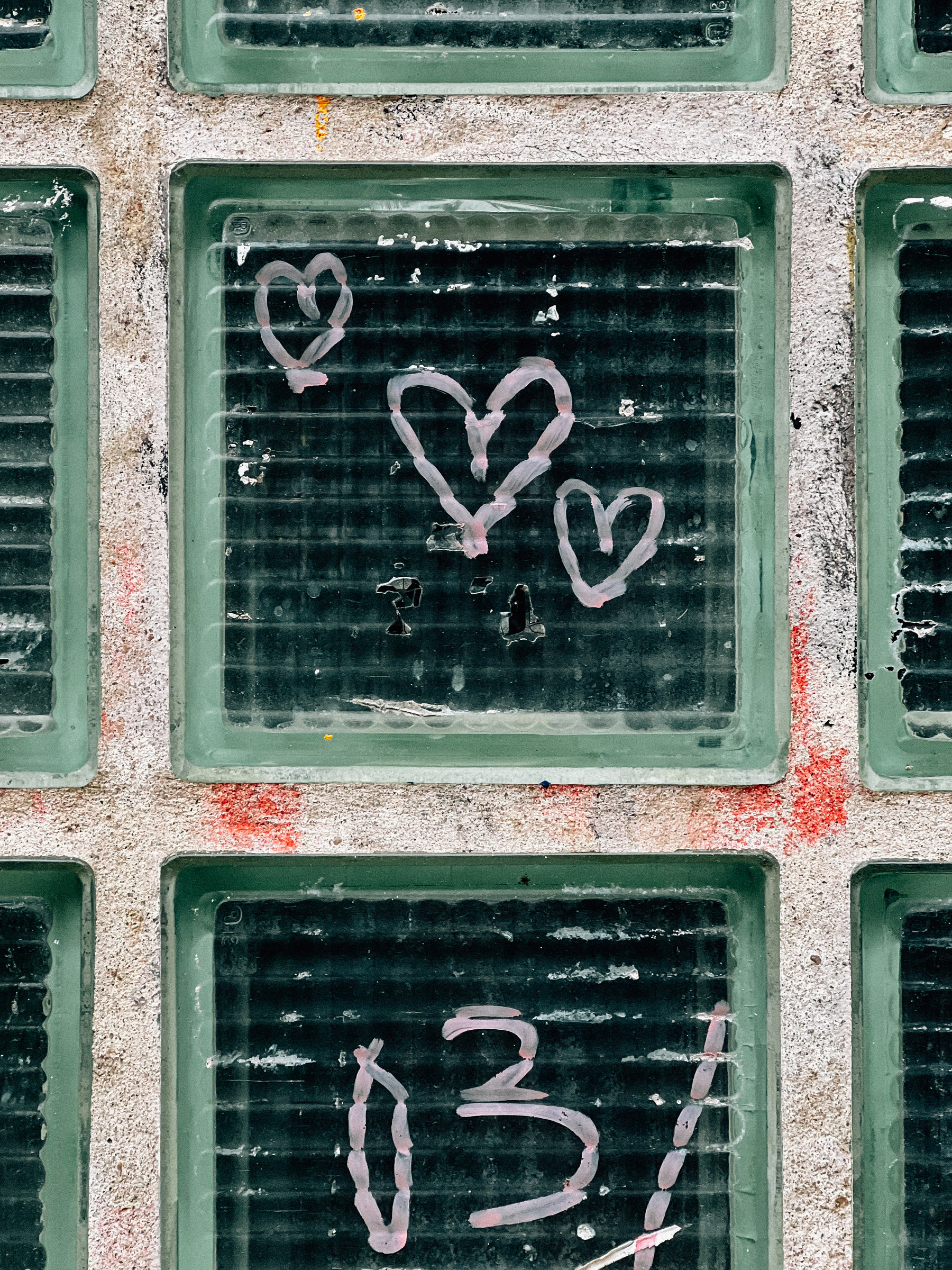 Glass blocks with graffiti painted hearts and the number 03.