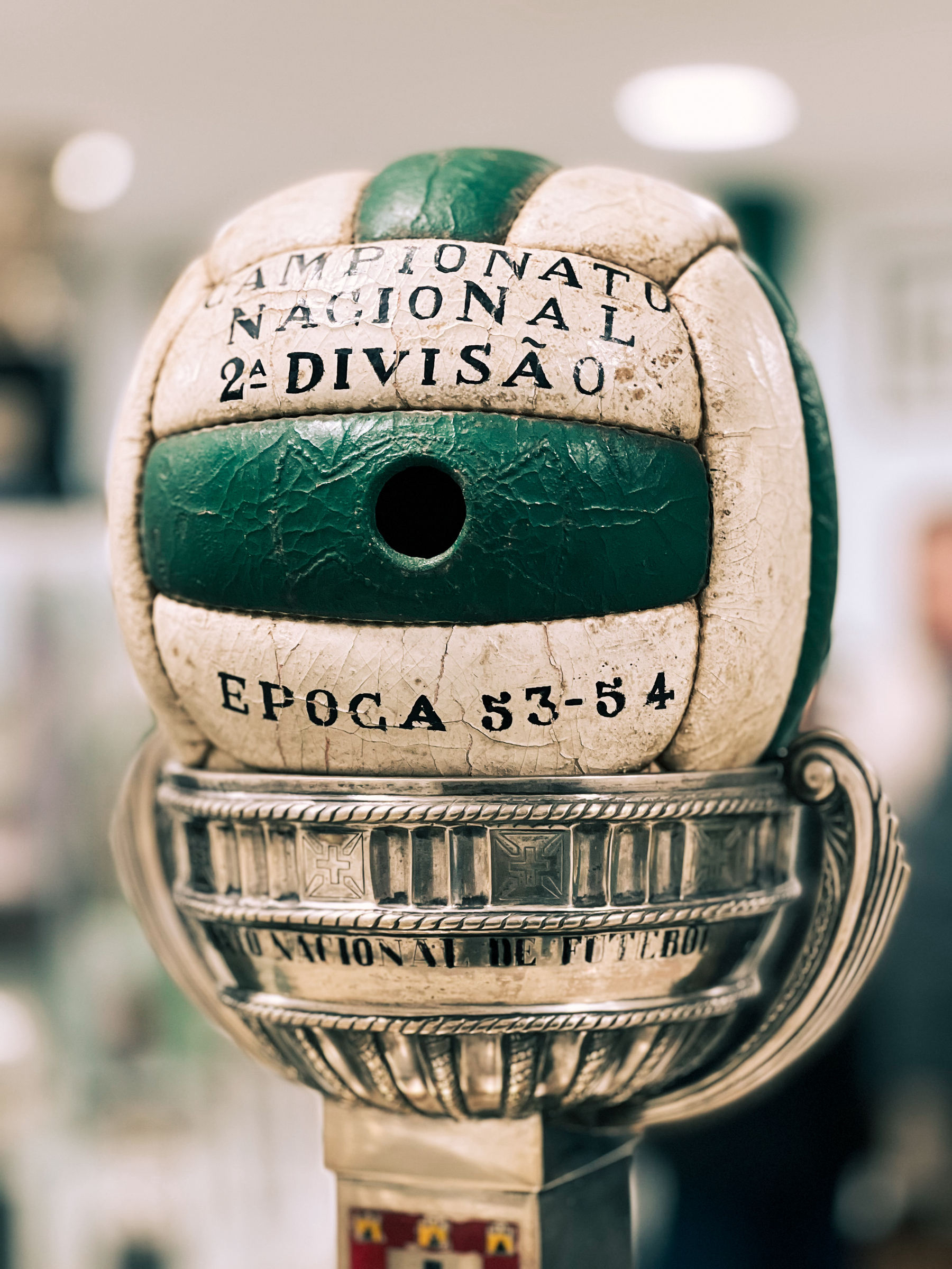 A close-up of a vintage leather soccer ball mounted on top of a trophy.