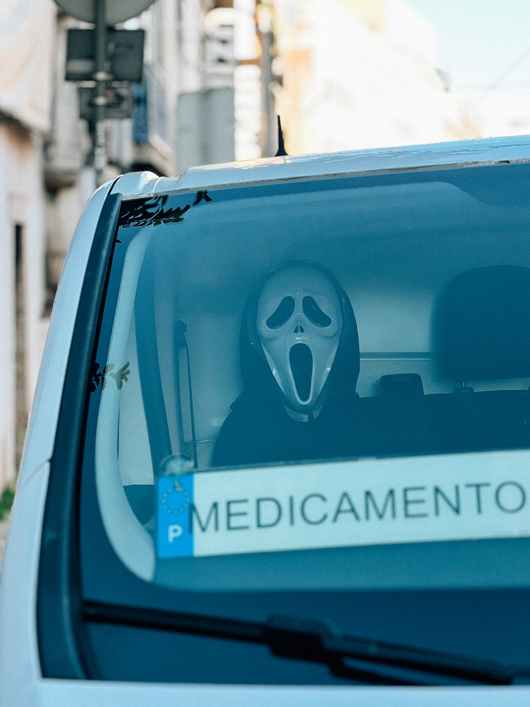 Mask similar to the &ldquo;Ghostface&rdquo; mask from the &ldquo;Scream&rdquo; movie series seen inside a vehicle with a sign that reads &ldquo;MEDICAMENTOS,&rdquo; suggesting it&rsquo;s a medical services or pharmacy delivery van.
