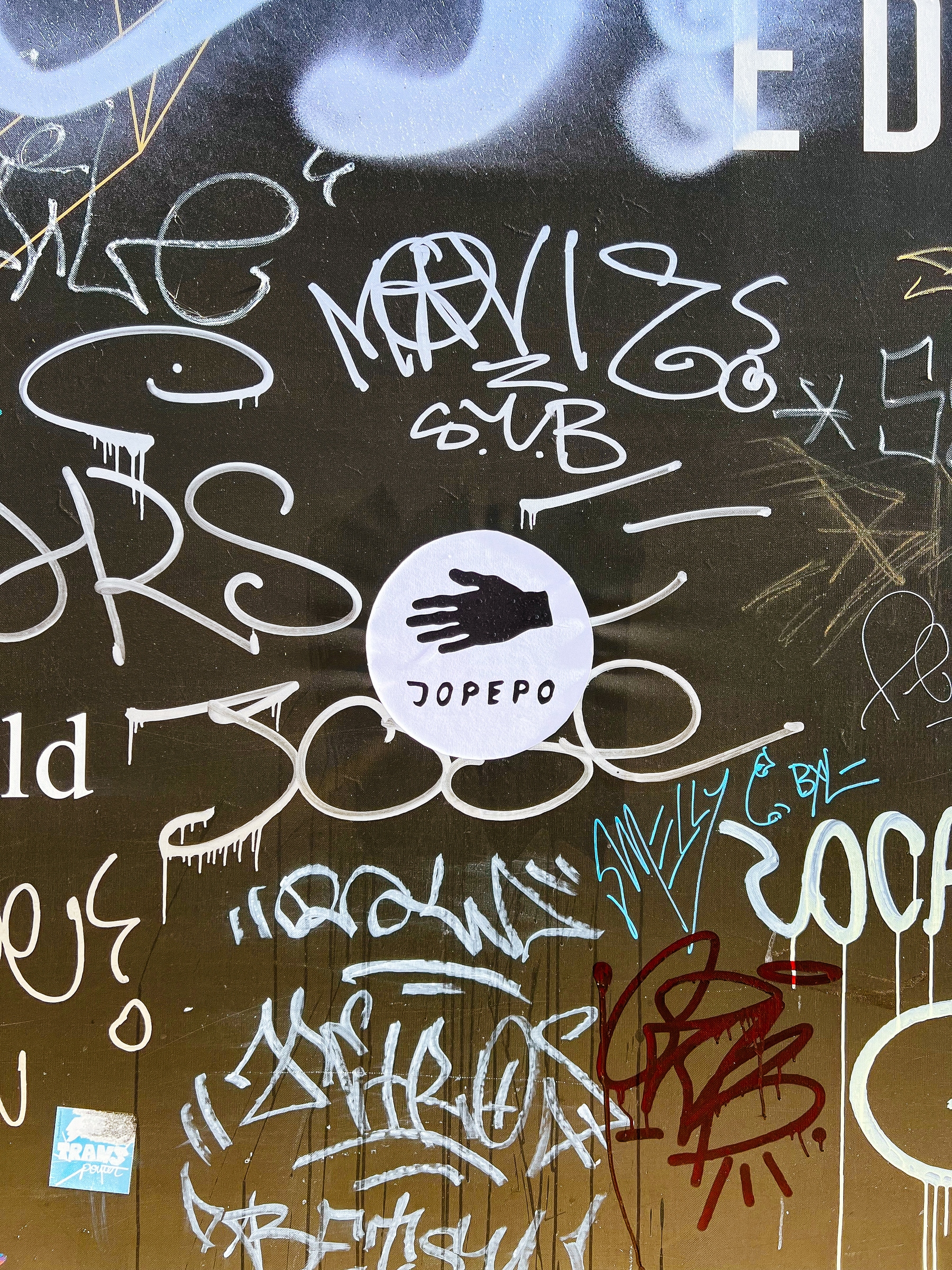 “Jopepo”, and a hand. Lots of graffiti tags around. A sticker. 