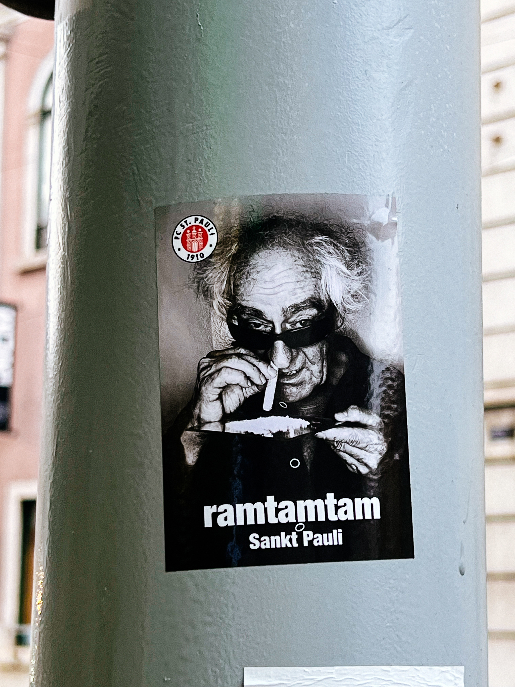 Sticker with the photo of an older gentleman with what looks like some powdered cocaine. It’s probably not. “ramtamtam”. 