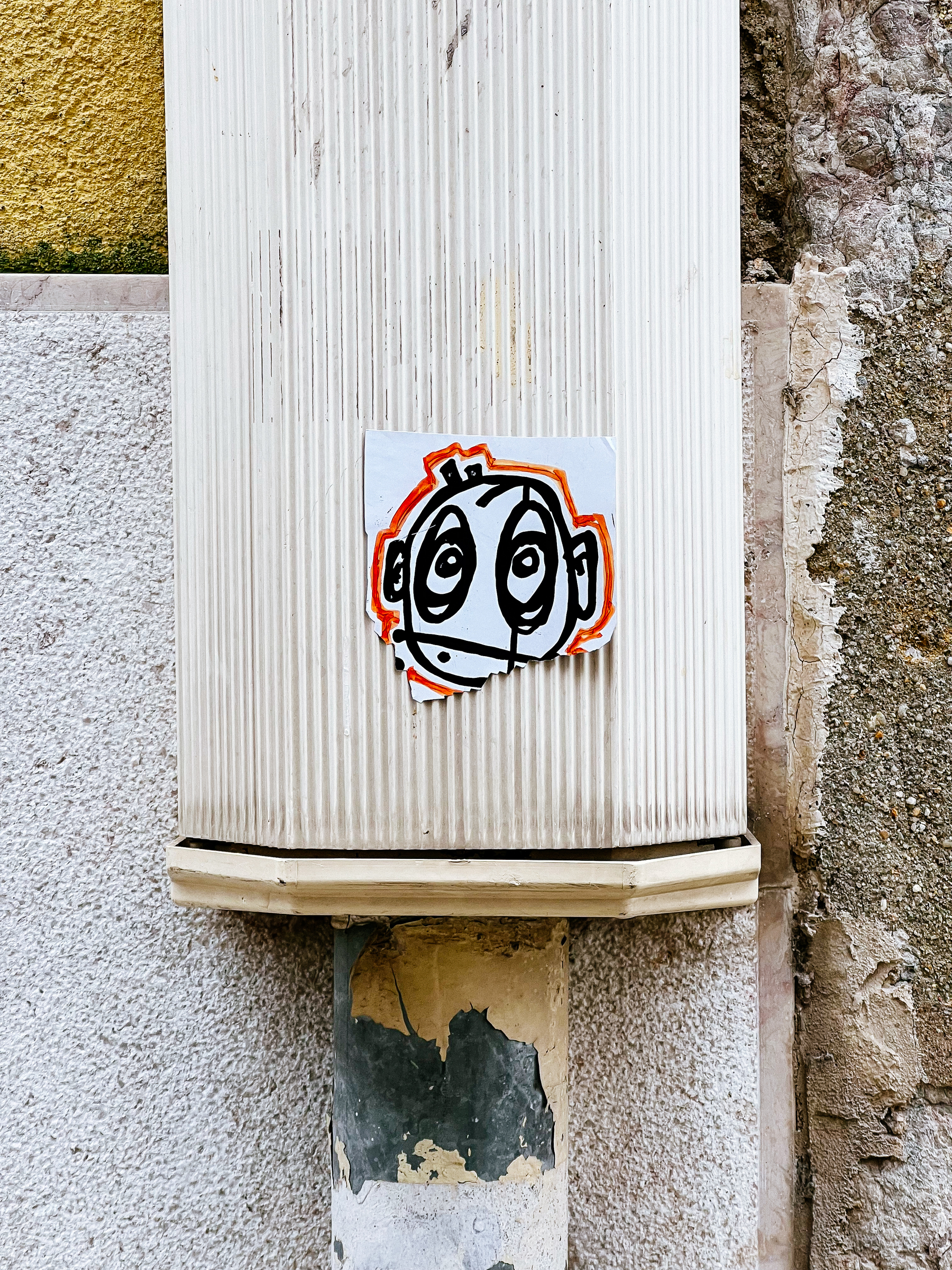 A face, hand drawn, on a sticker. 