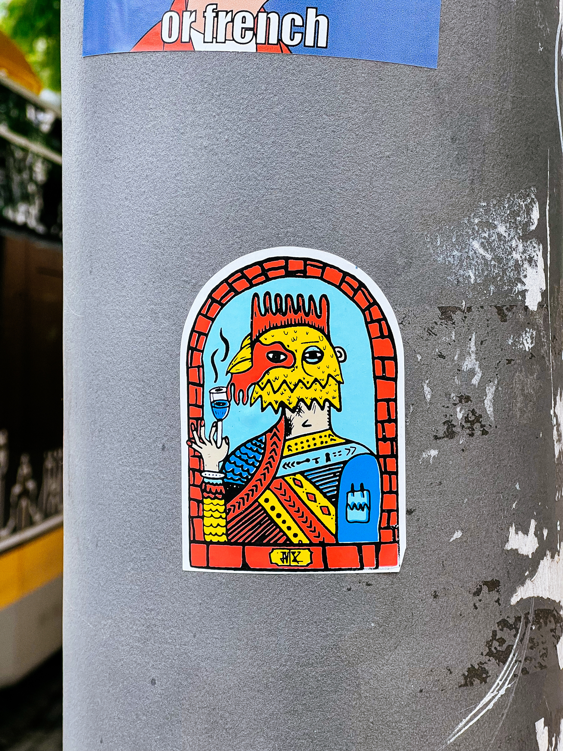 A colorful sticker depicting a stylized creature drinking from a cup.