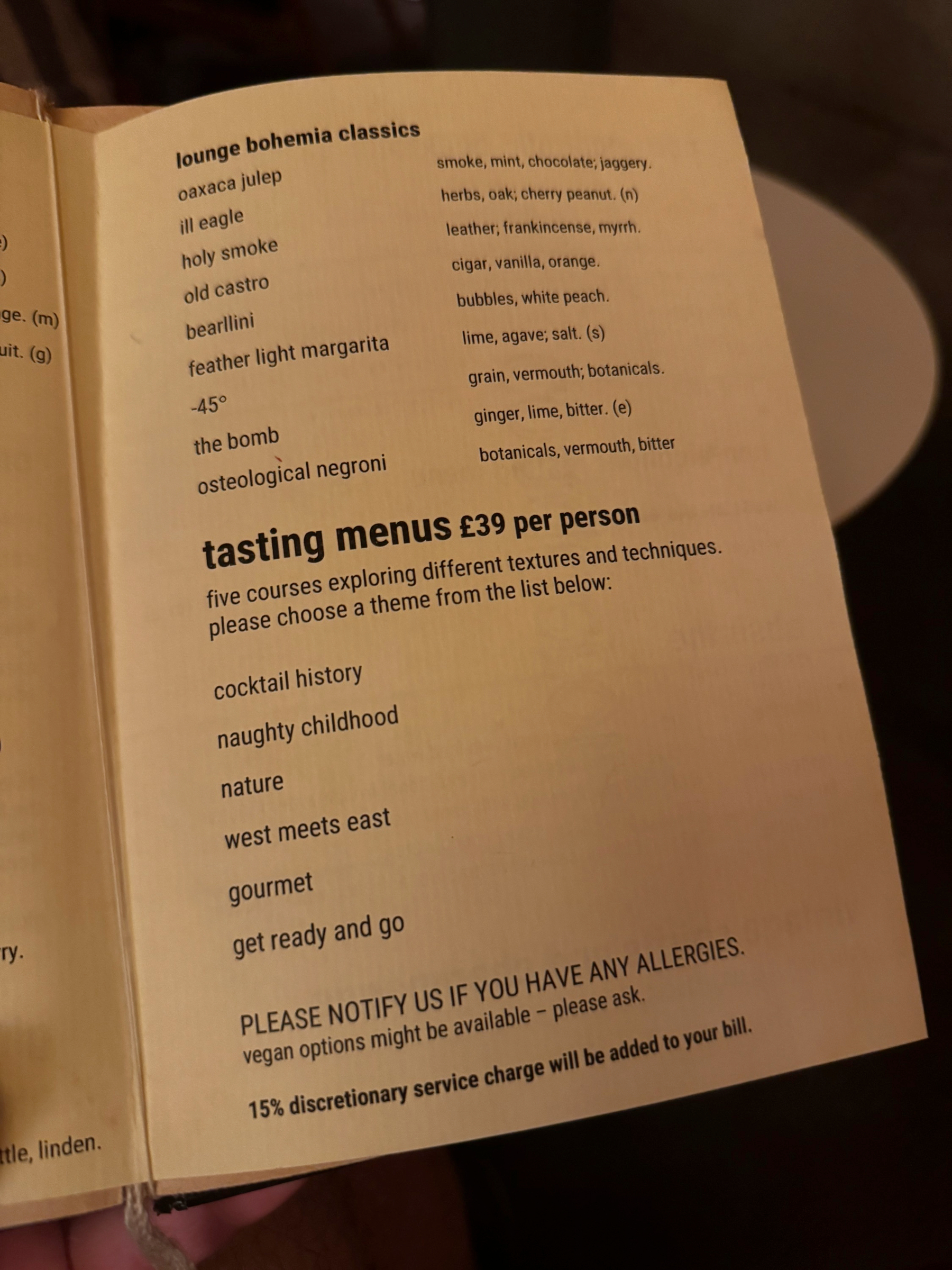An open menu listing classic cocktails and five-course tasting menus, including themes such as “naughty childhood,” “nature,” and “west meets east.”