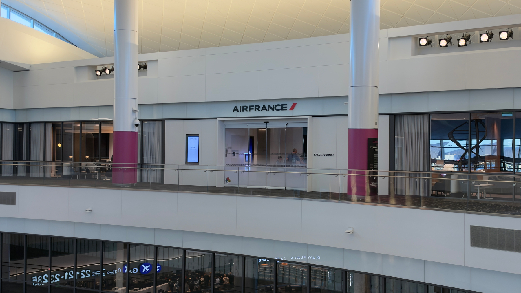 The Air France lounge is located inside a modern airport terminal with white walls and large windows.