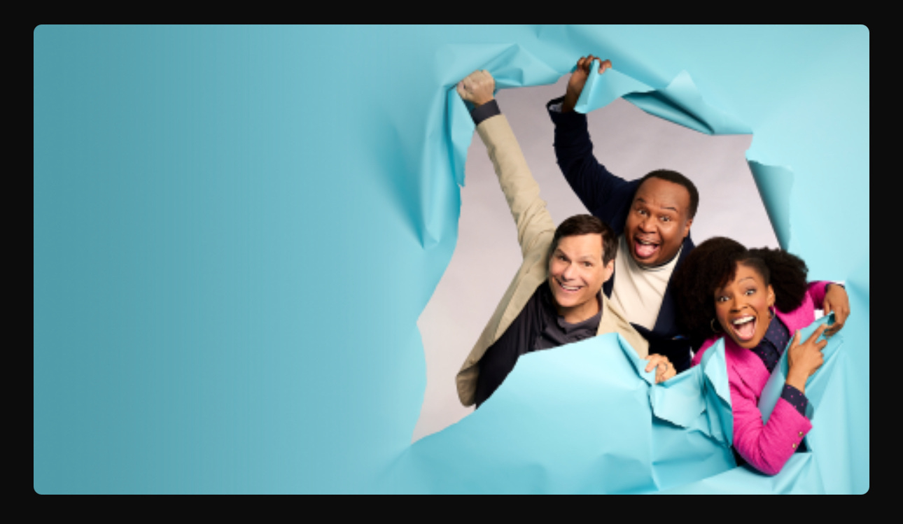 A promo photo for "Have I Got News For You":&10;&10;Roy Wood Jr., Amber Ruffin, and Michael Ian Black are breaking through a screen that is the color of robin's egg blue.&10;&10;Perhaps this is a play on "breaking news"?&10;&10;Either way, these are 3 delightful comedians. I'm a big fan. 