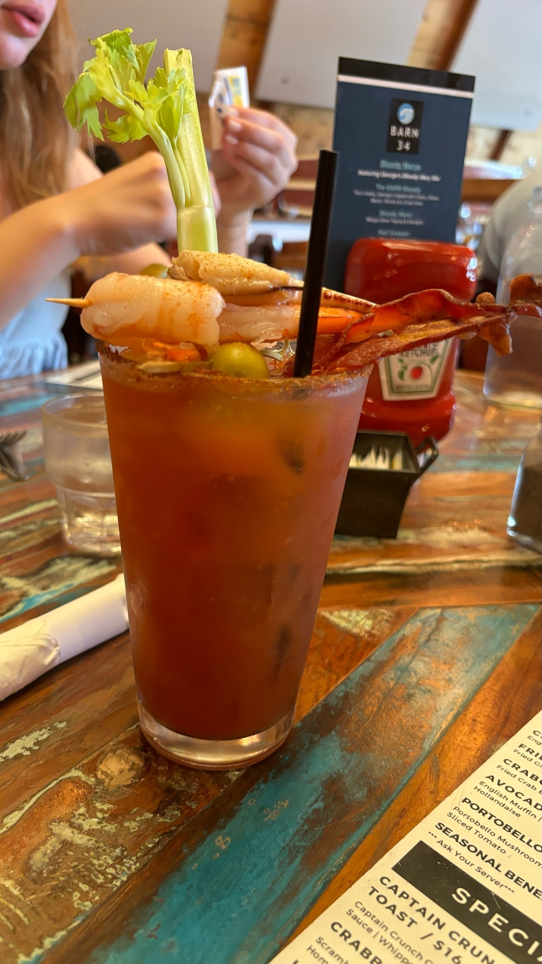 A Bloody Mary, served in a pint glass, with garnishes including: celery, bacon, 2 shrimps, olives, and a crab claw. Yum. 