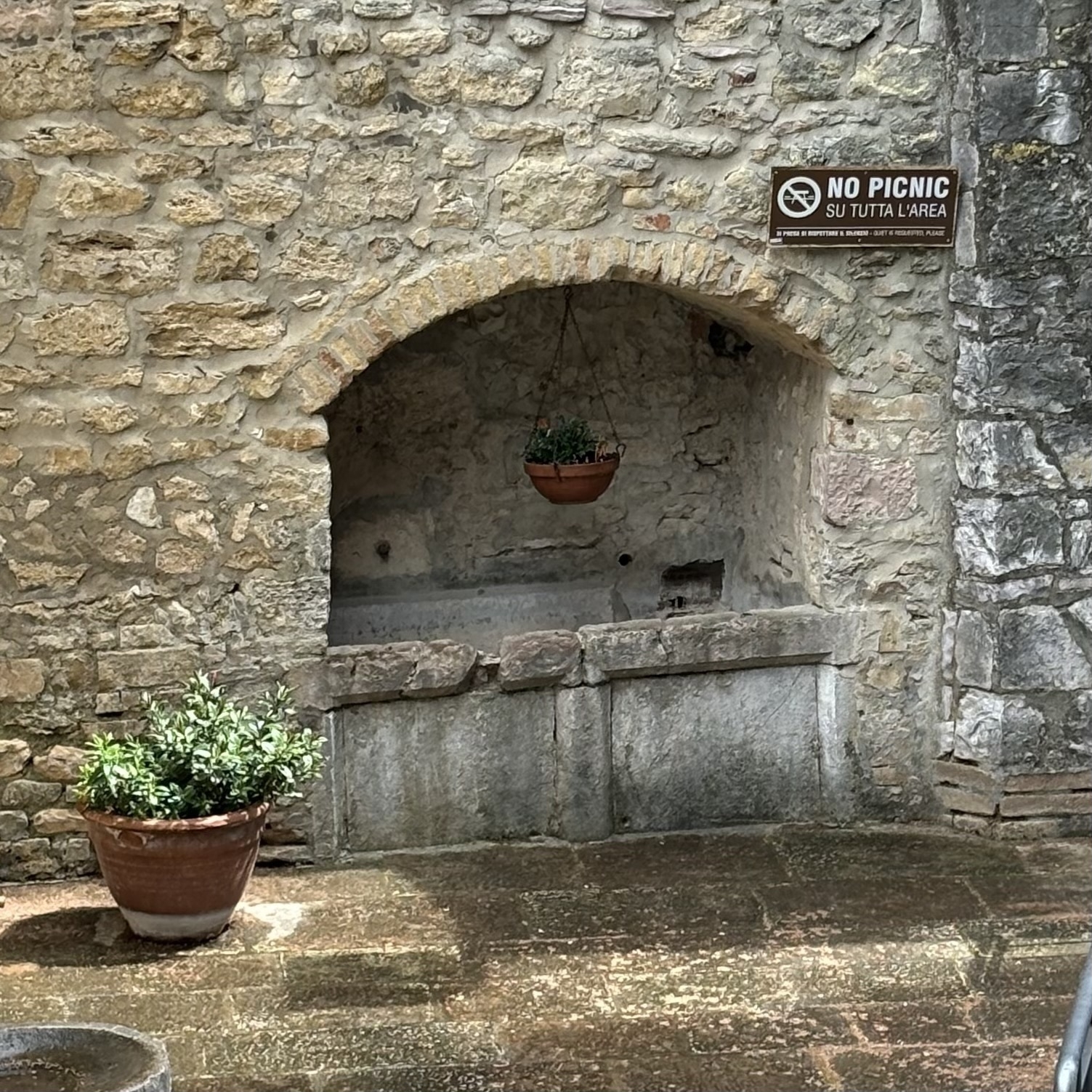 a sign that reads: NO PICNIC outside the Chiesa San Damiano in Assisi, Italy