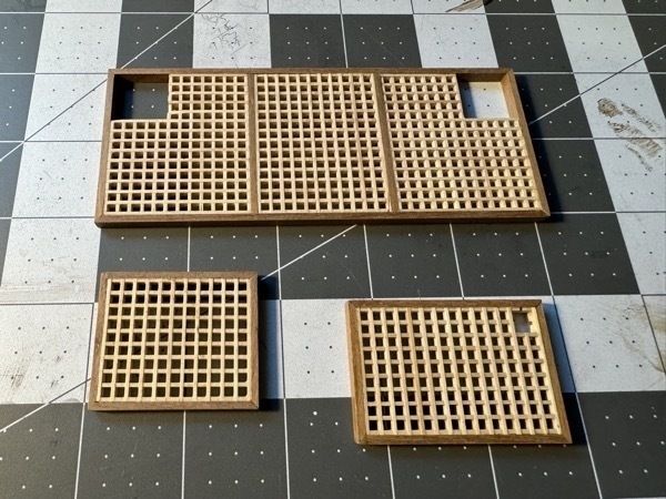 Completed deck grating for flying dutchman model ship. Grid of light-colored wood outlined in darker mahogany. 