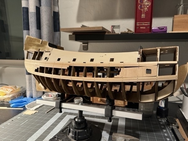 View of starboard side of Flying Dutchman with planking on the top half. 