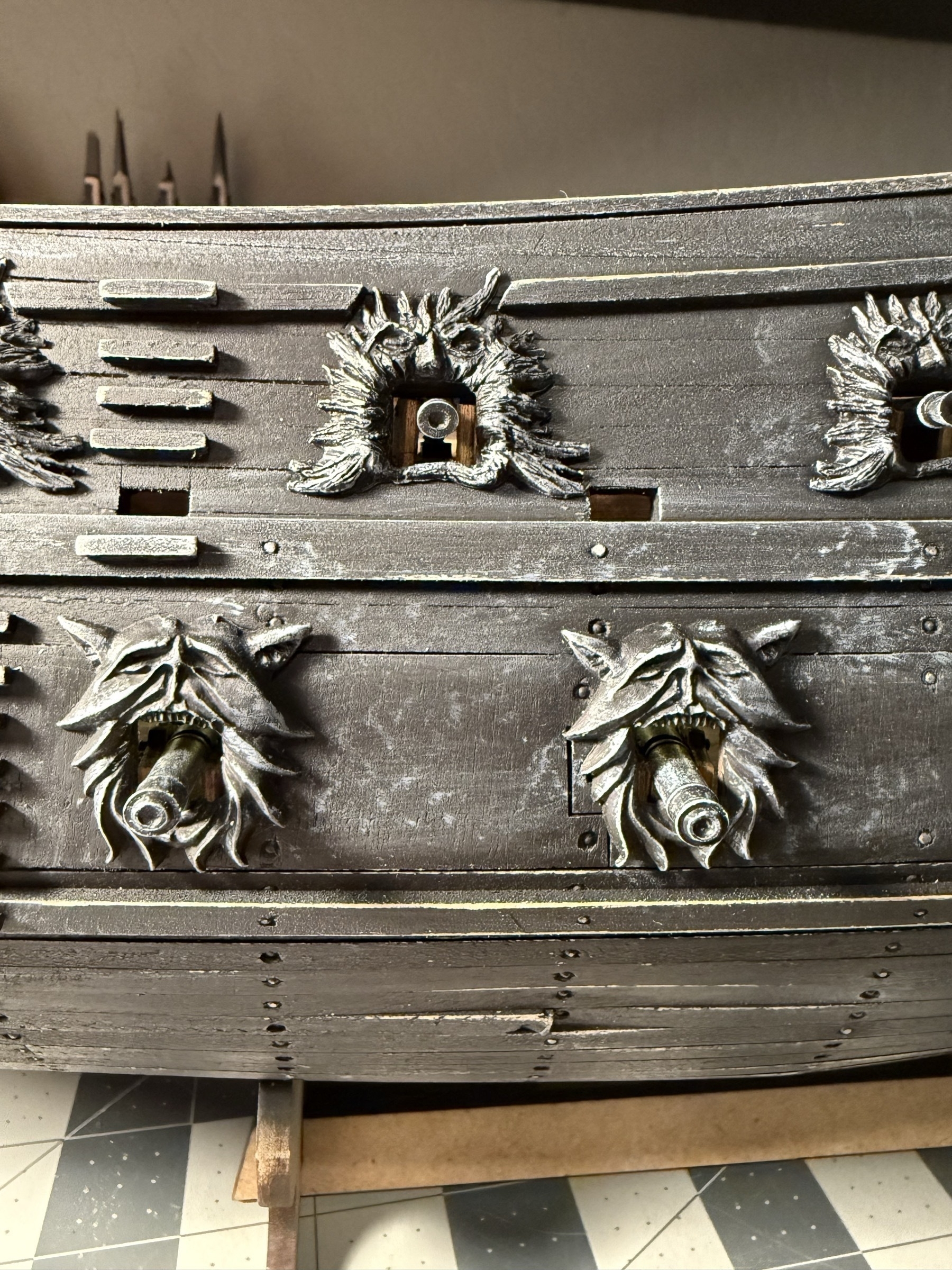 Close up view of a few of the cannons sticking out of the port side of the flying dutchman model ship. 