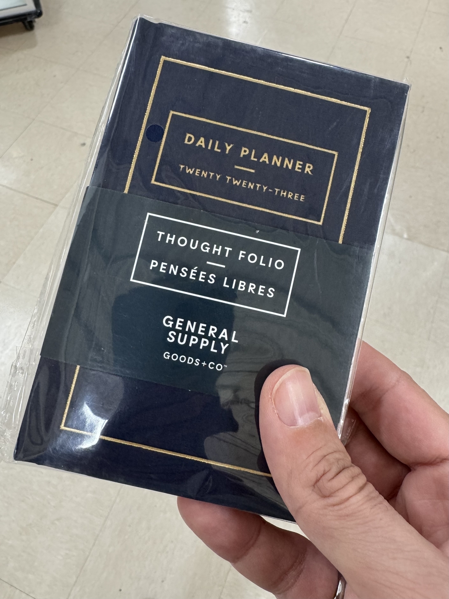 A hand is holding a packaged 2023 daily planner labeled "Thought Folio" by General Supply Goods + Co.